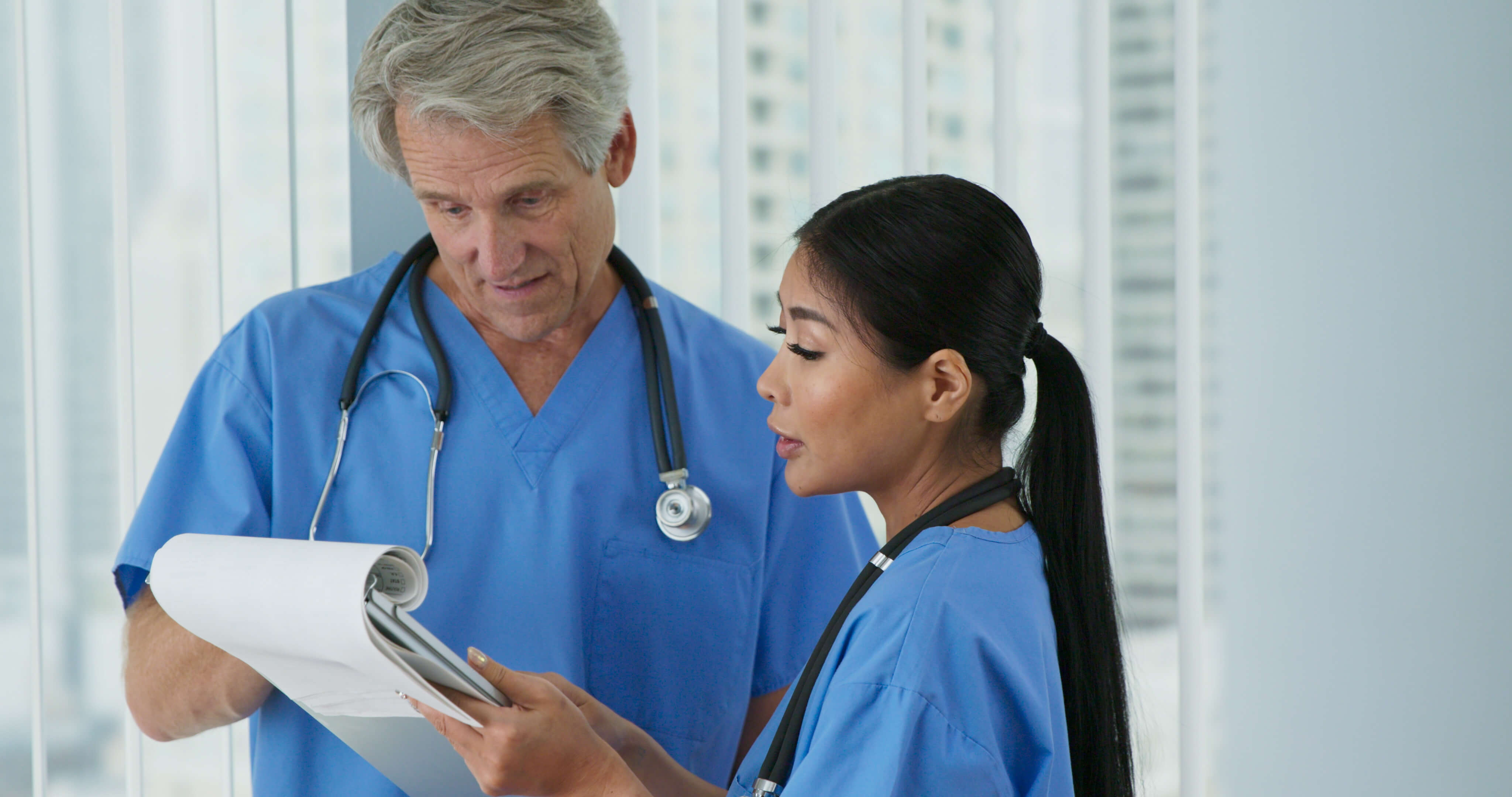 Physician and nurse reviewing a patient chart together