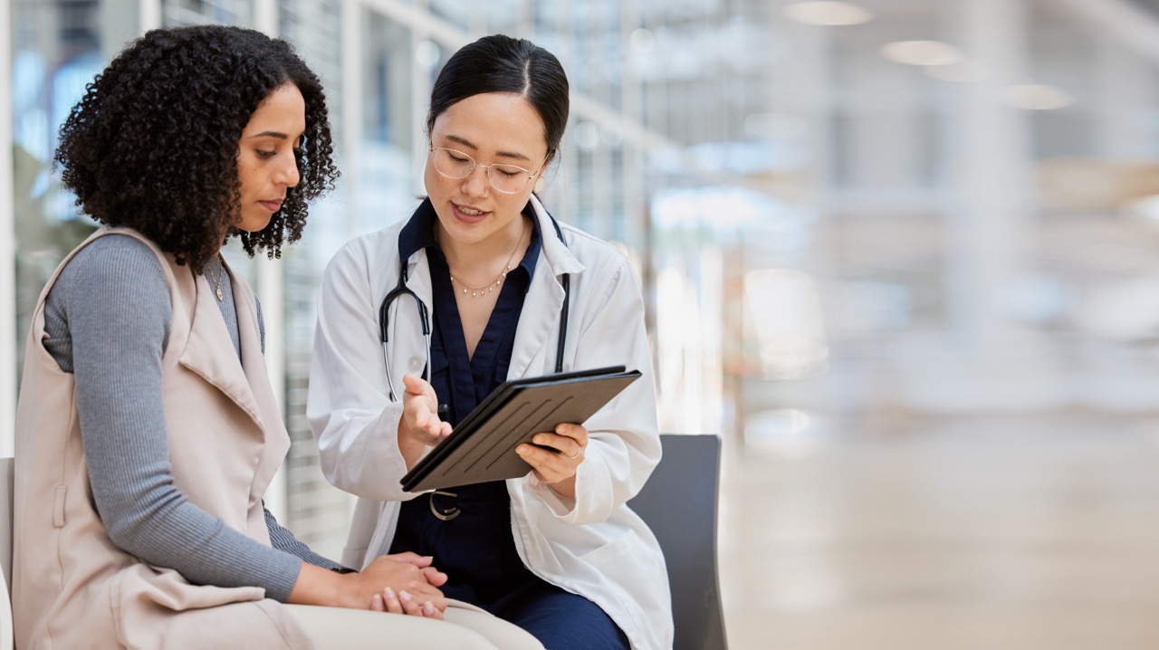 Physician reviewing results on a tablet with a patient