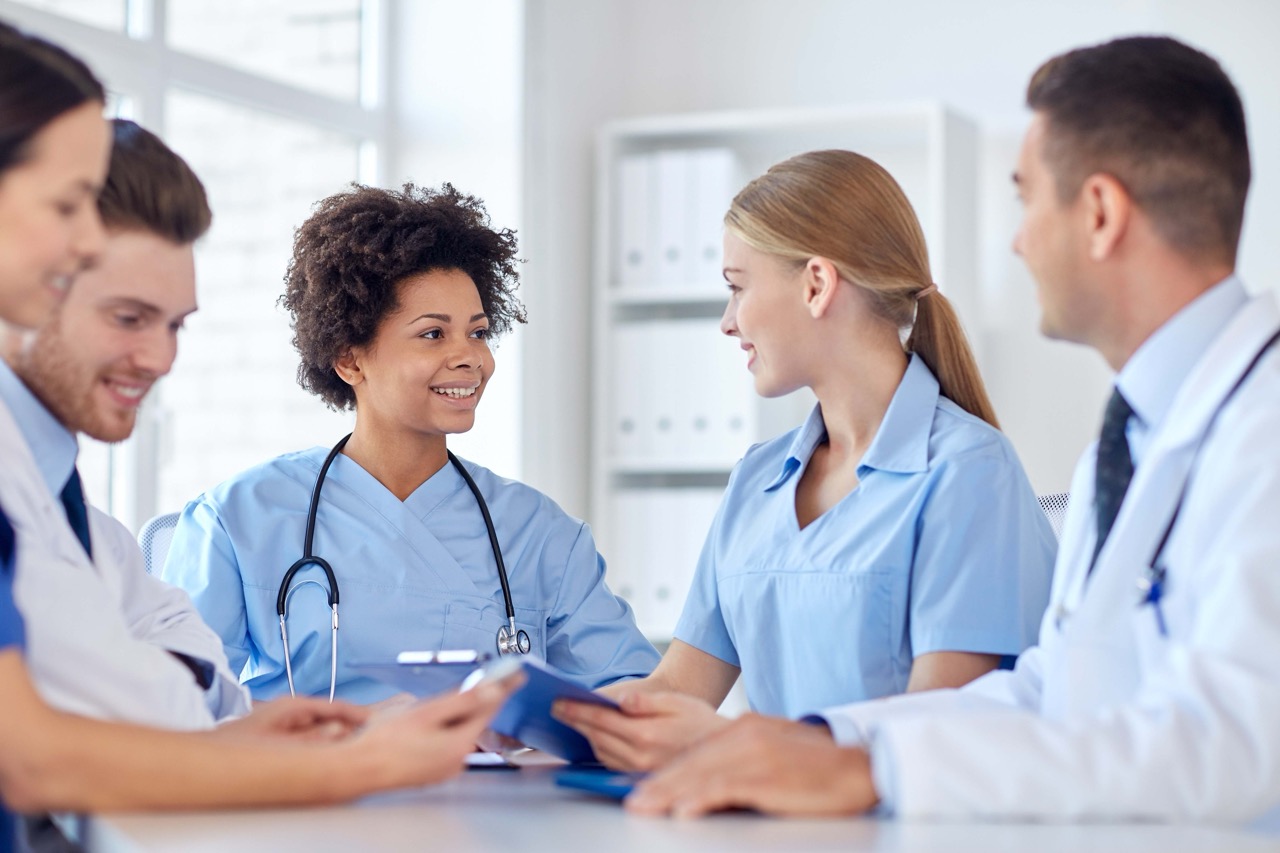 Care team of doctors and nurses meeting around a table