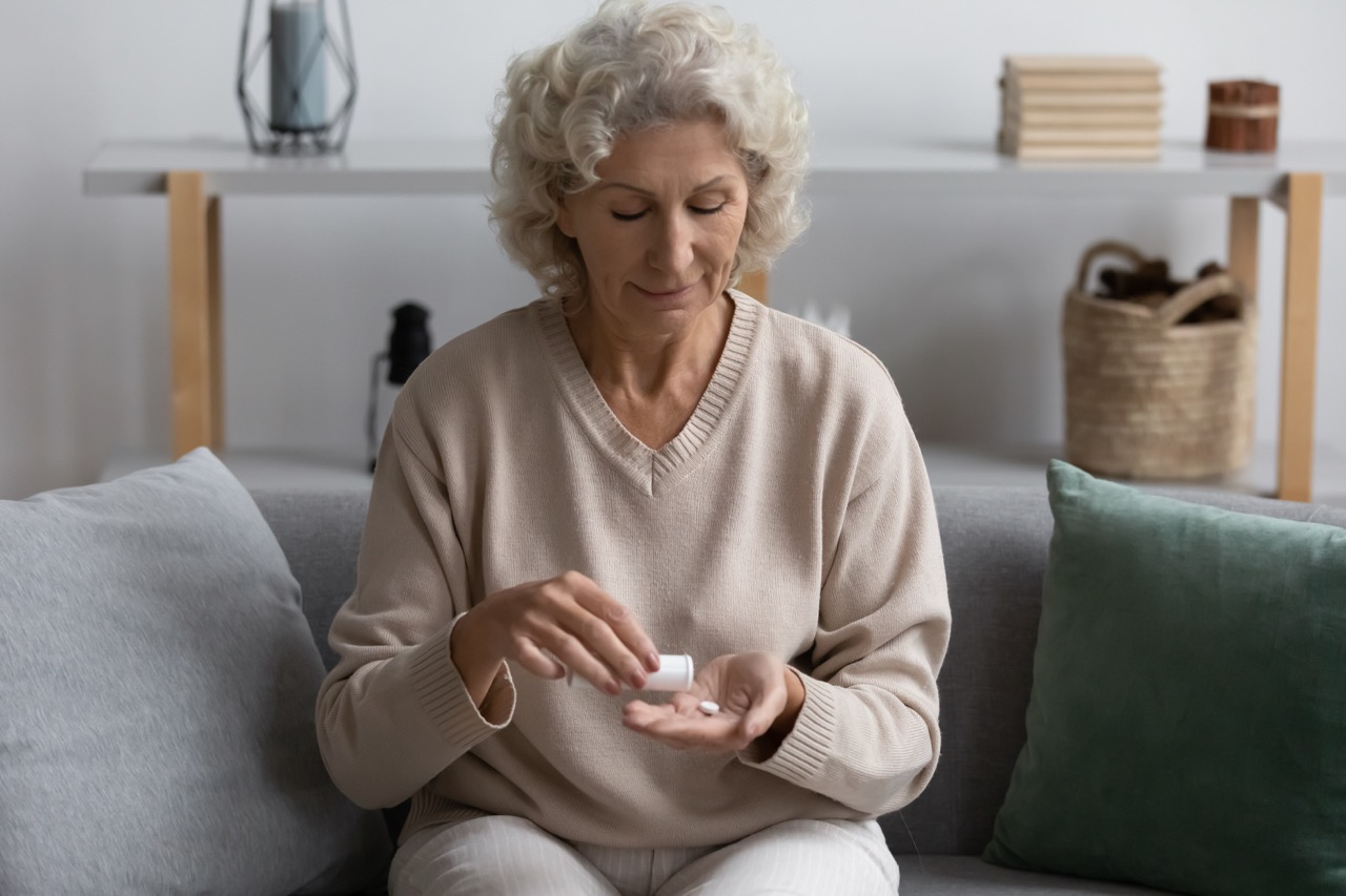 Senior woman taking daily medication at home