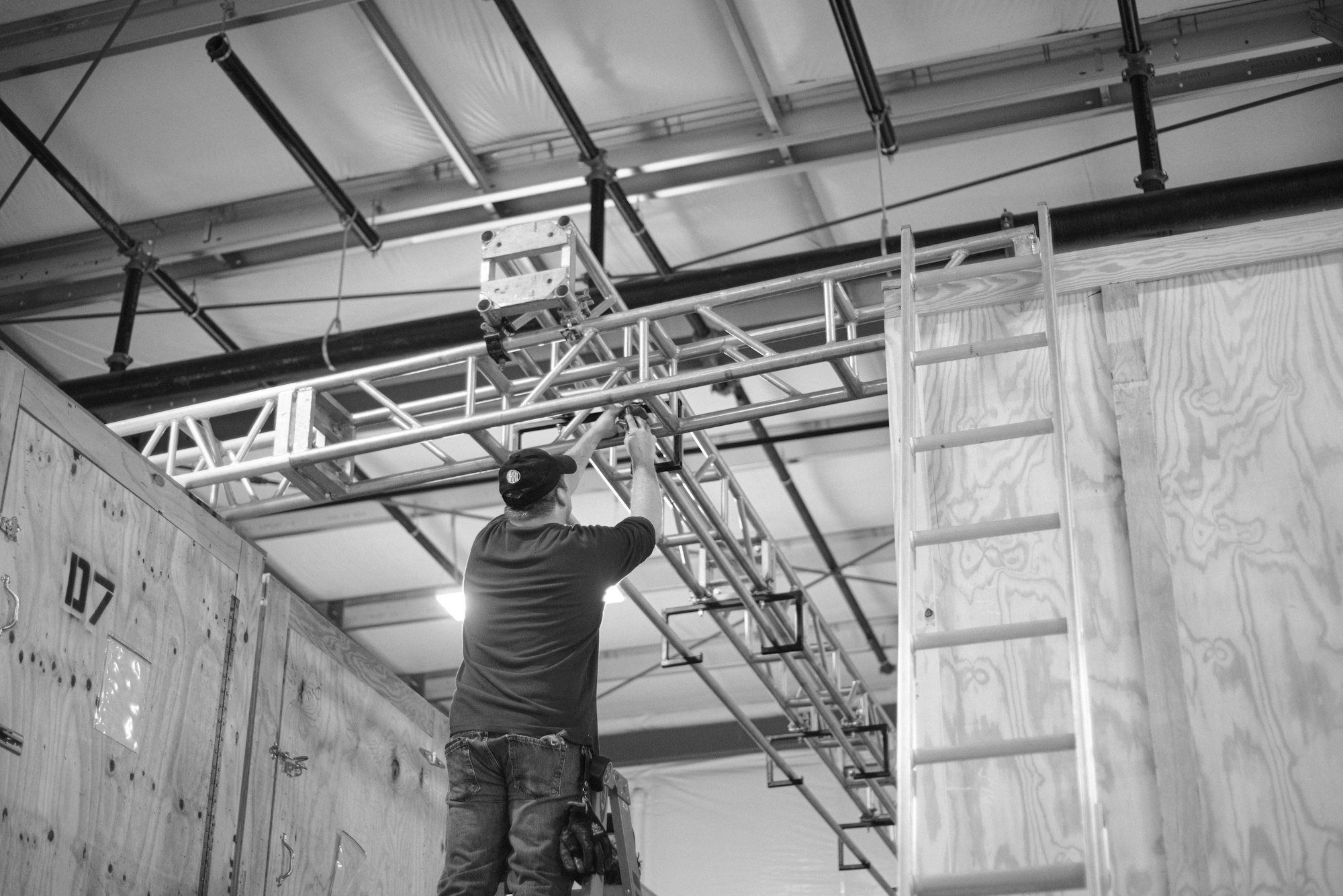 Technician on a ladder installing overhead infrastructure