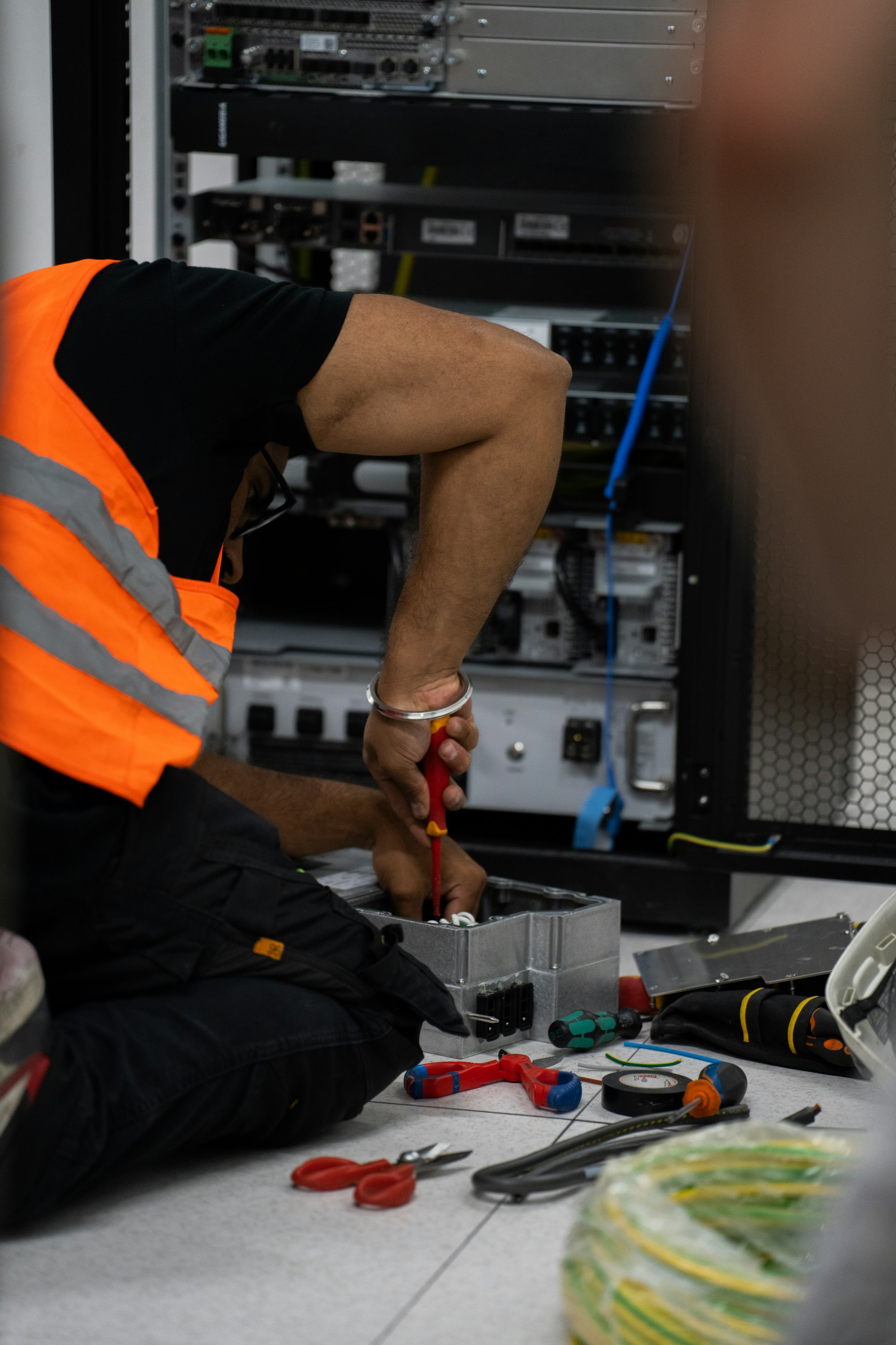 Technician using tools on network equipment on site