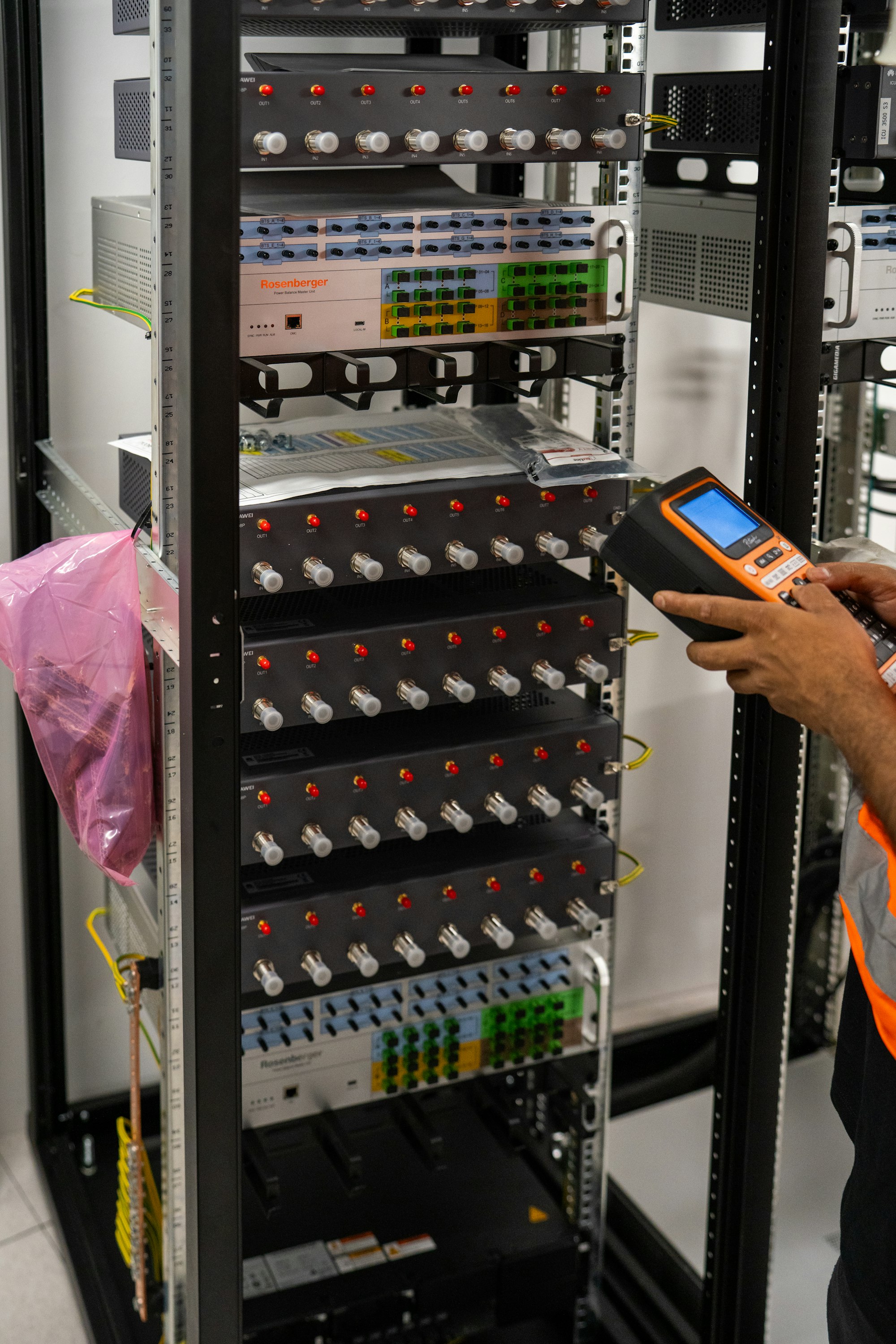 Technician testing a network rack with a handheld tester