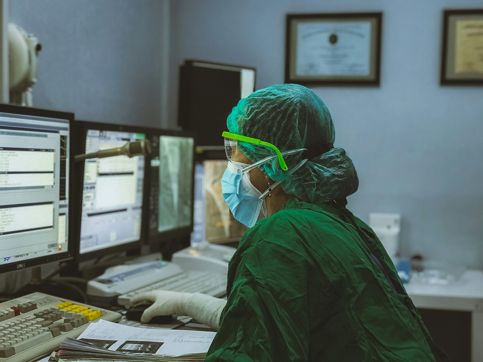 Clinician working at a multi-monitor hospital workstation