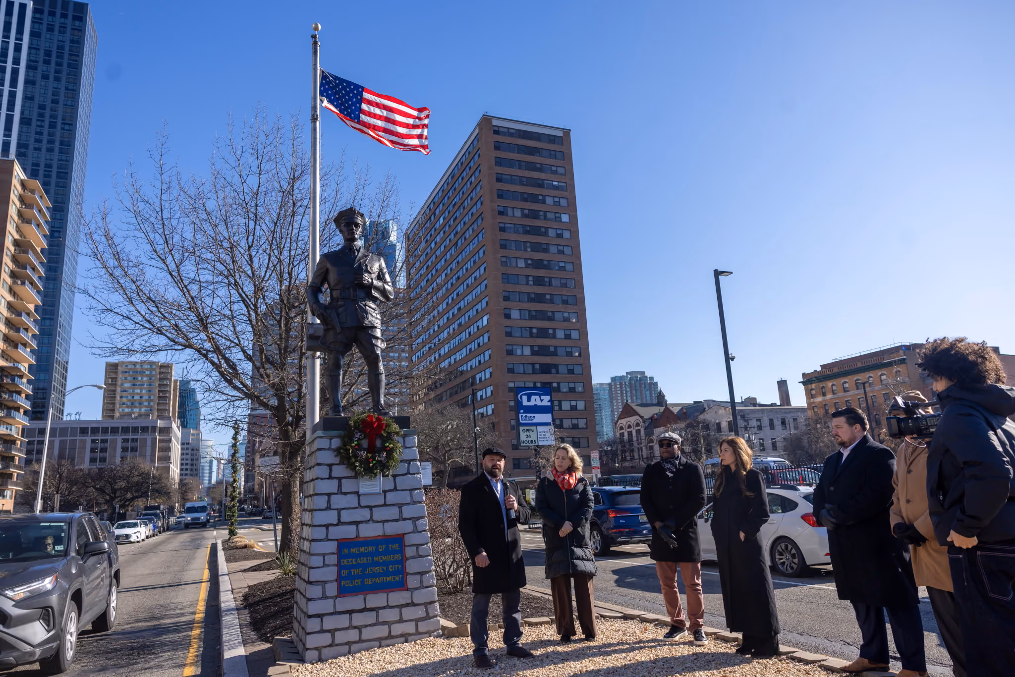 The Jersey City Police Department memorial statue with wreath and American flag