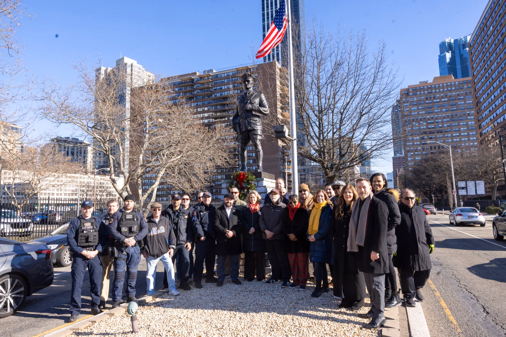Officers and community members gathered around the statue