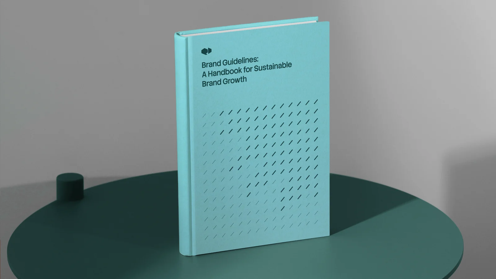 Hardcover brand guidelines book on a teal table