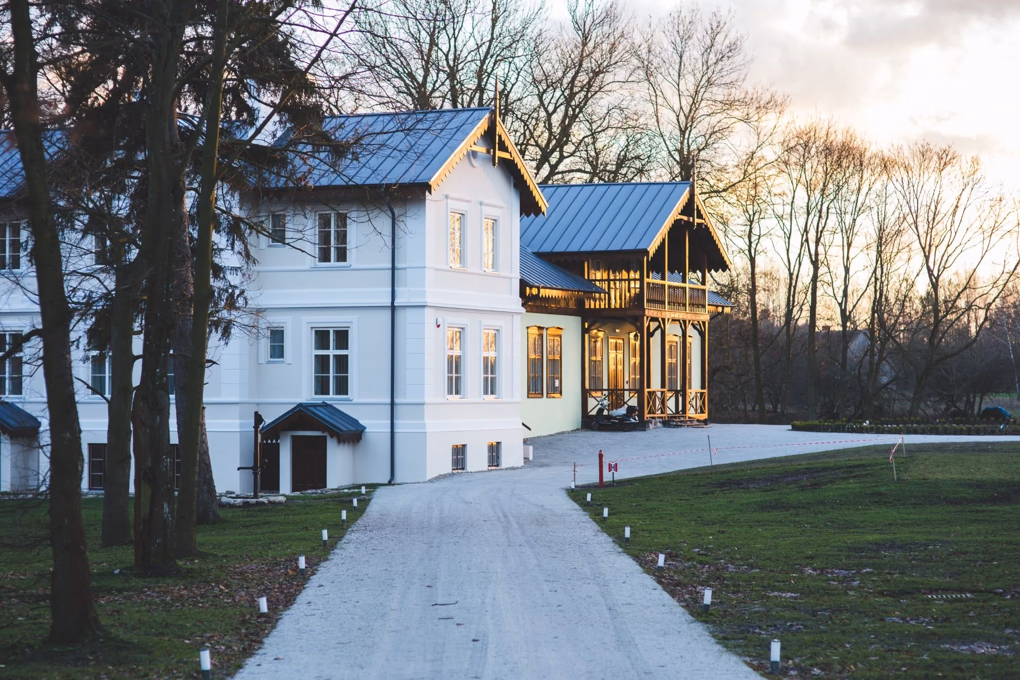 White two-storey home with a long driveway