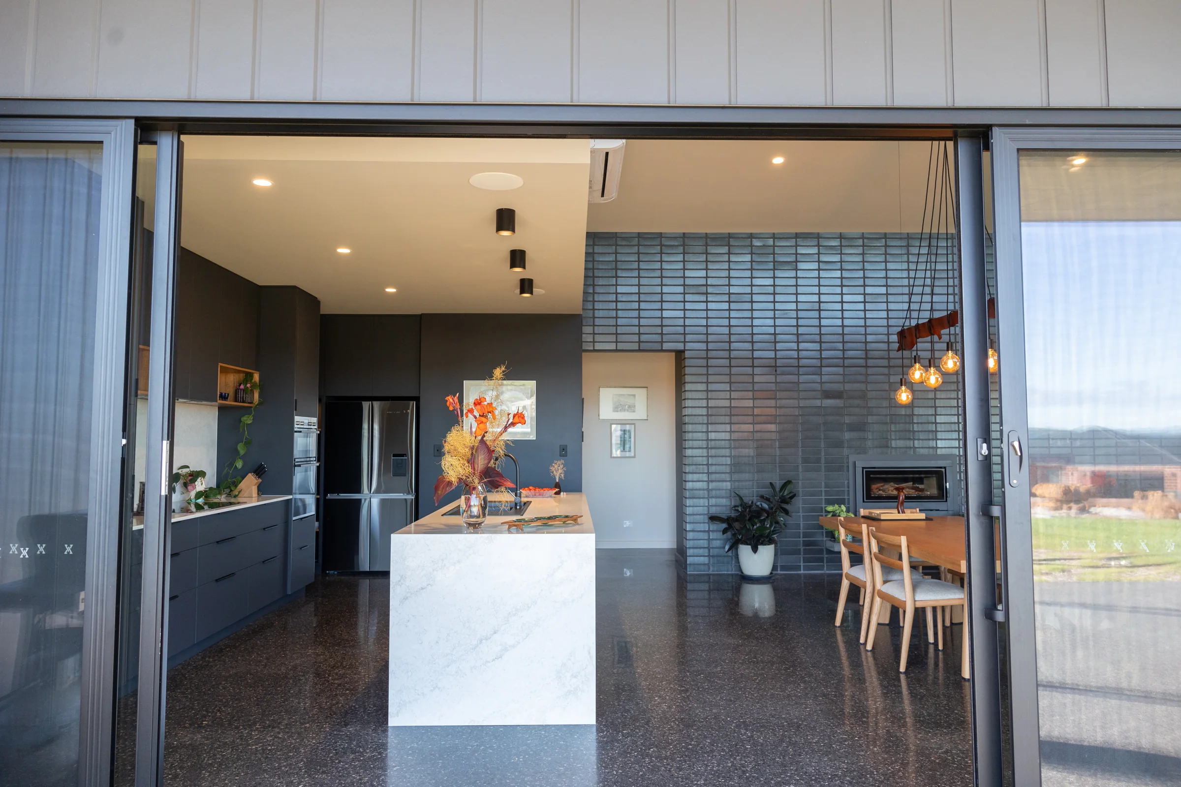 Kitchen and dining seen through open stacker doors