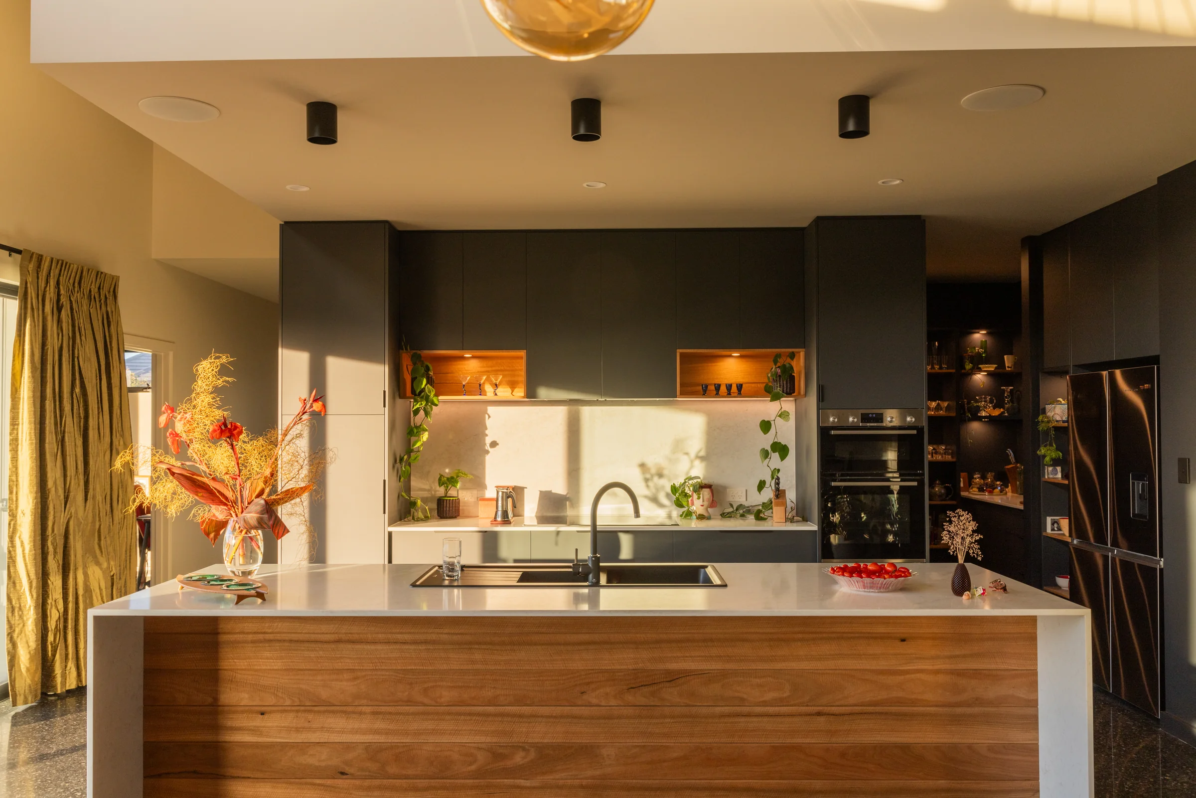 Kitchen island with timber-plank front in golden-hour light