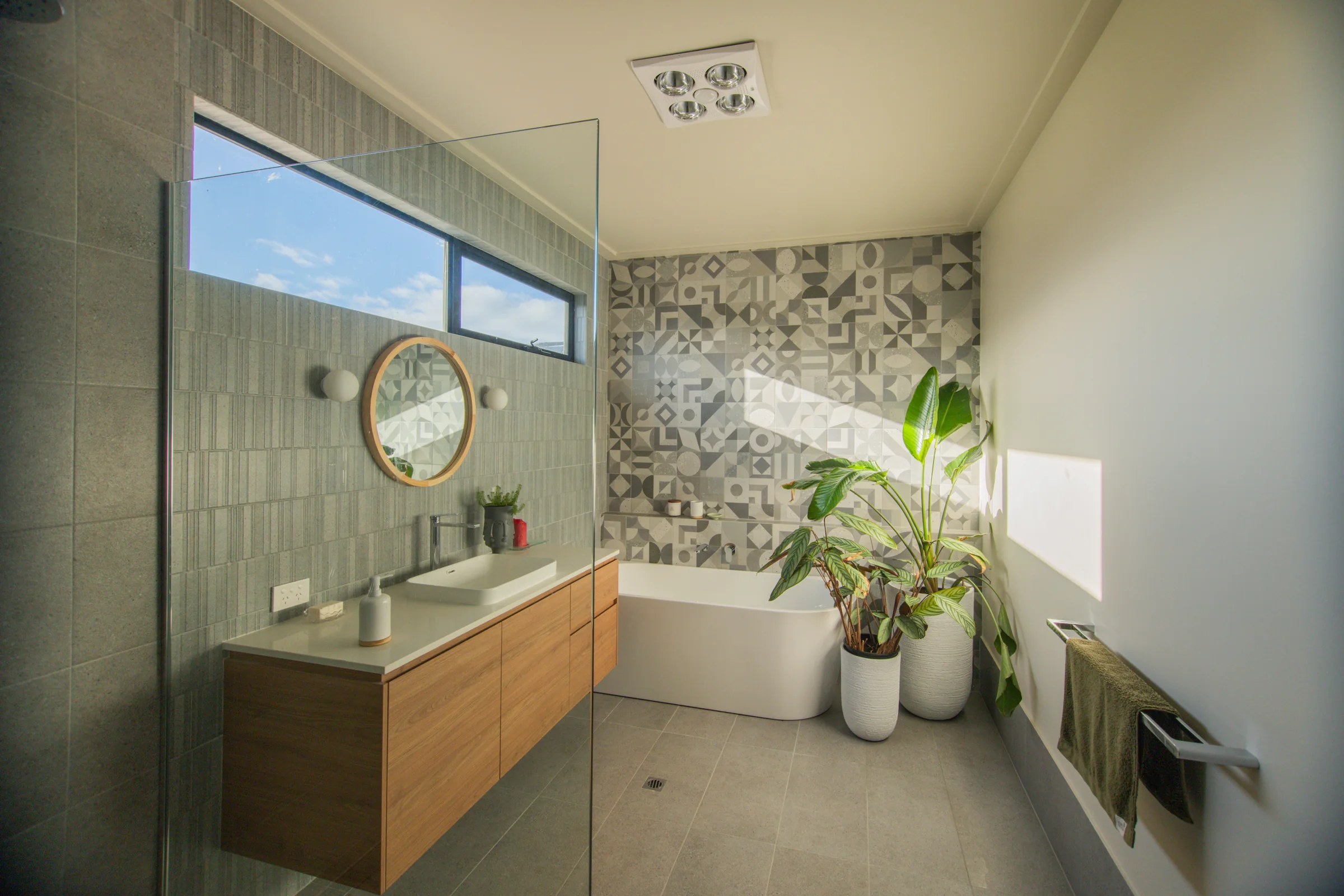Main bathroom with freestanding bath, timber vanity and geometric feature tiles