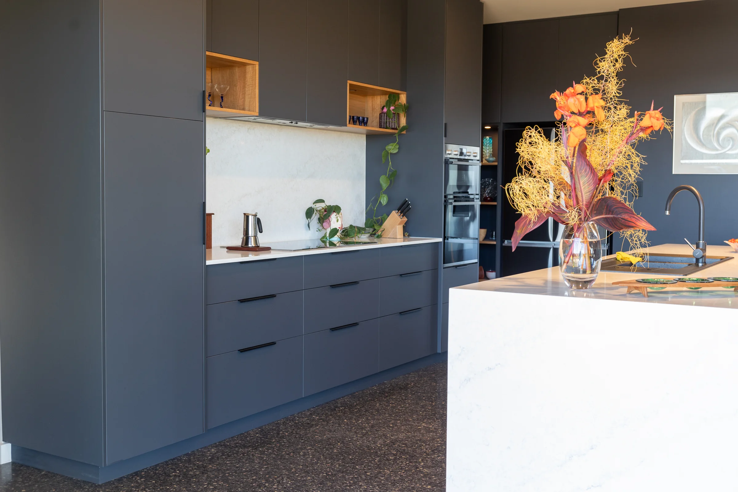 Charcoal kitchen joinery, timber cubbies and stone splashback