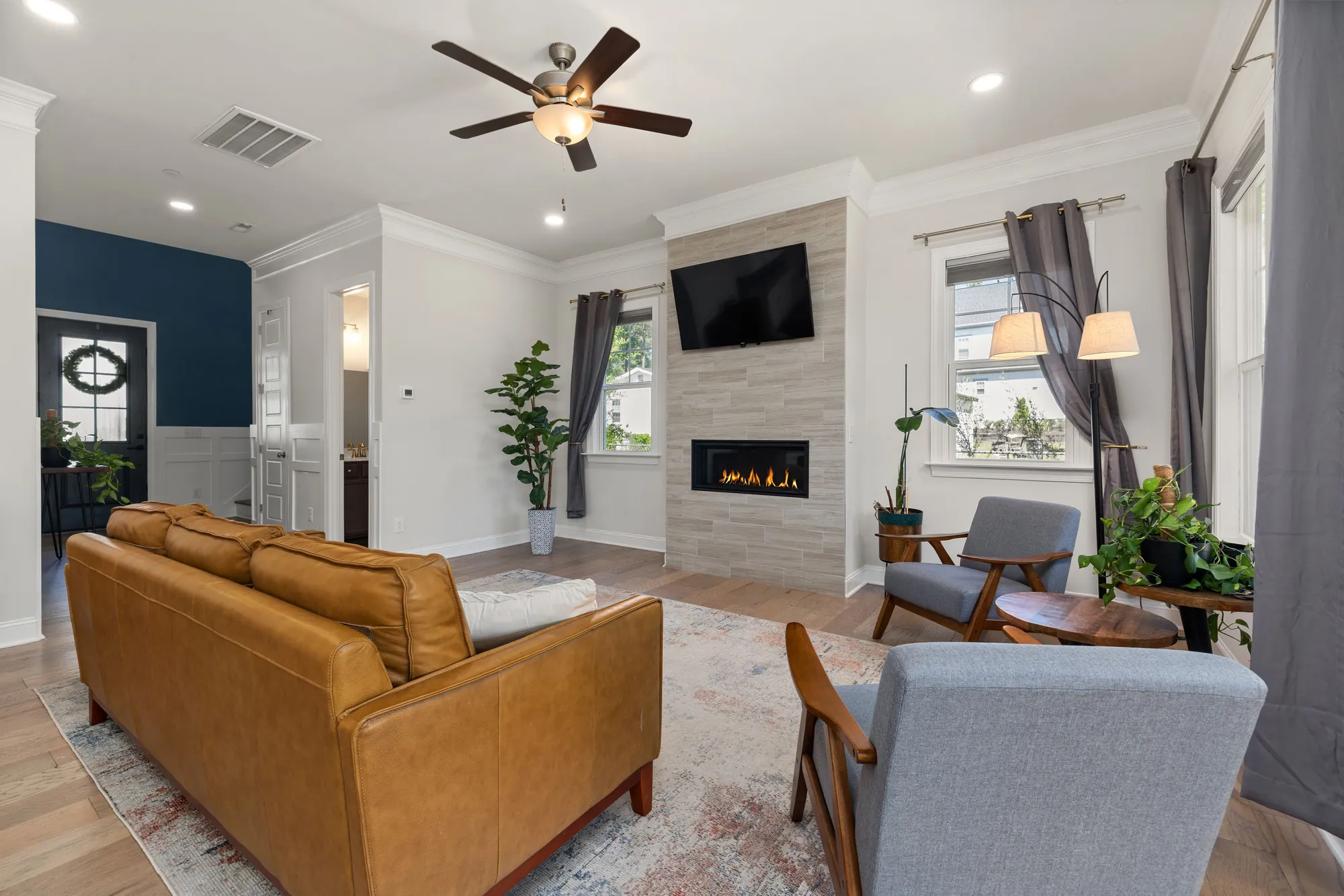 Finished room with a tile fireplace and gray armchairs