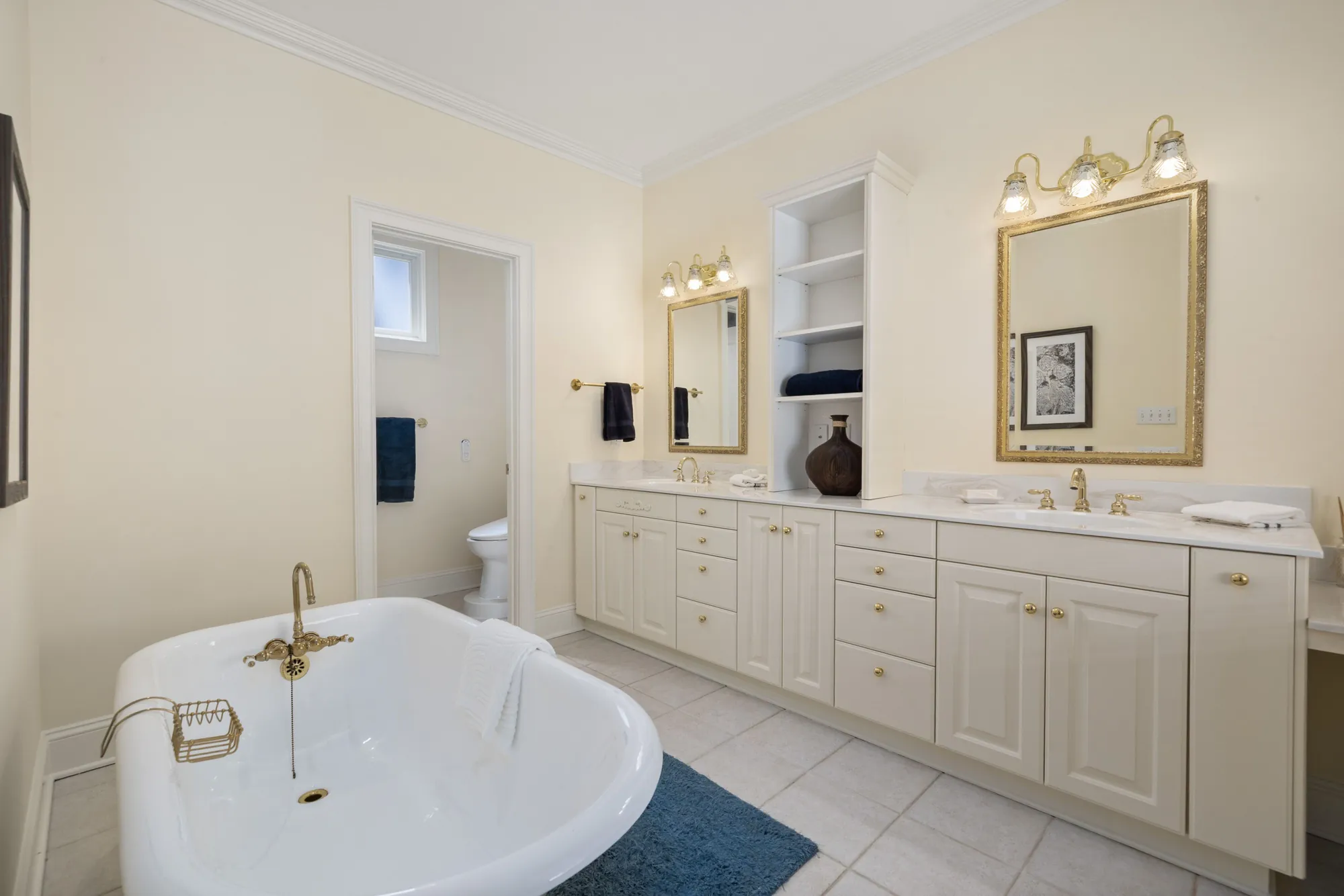 Bathroom with a cream clawfoot tub and a double vanity