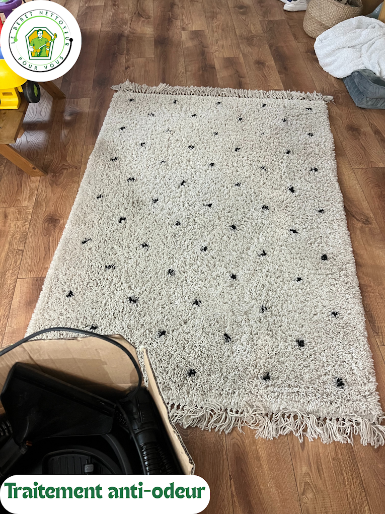 Tapis berbère blanc à pois noirs sur parquet, traité à l’injection-extraction contre les odeurs.