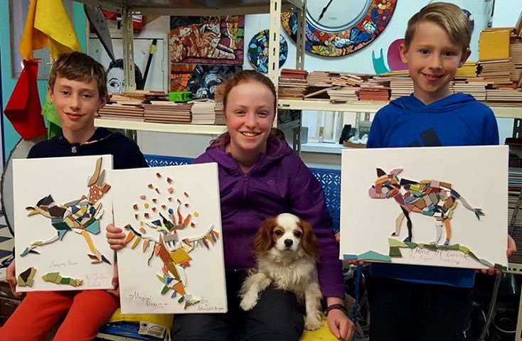 Students holding up their finished artwork at Art Studio 48