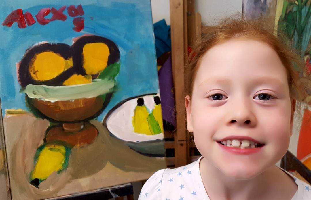 Student next to her still life fruit painting
