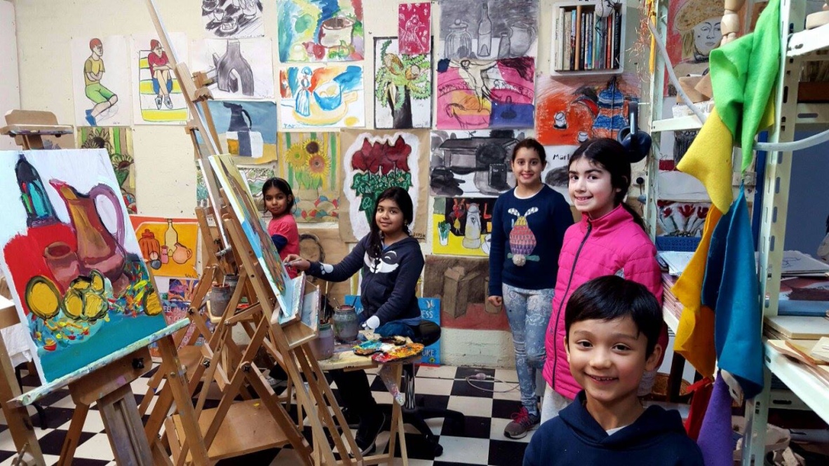Students working together in the studio surrounded by artwork