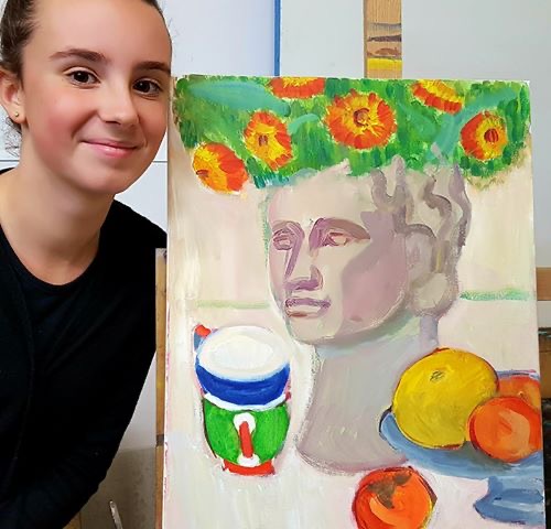 Student next to her still life painting