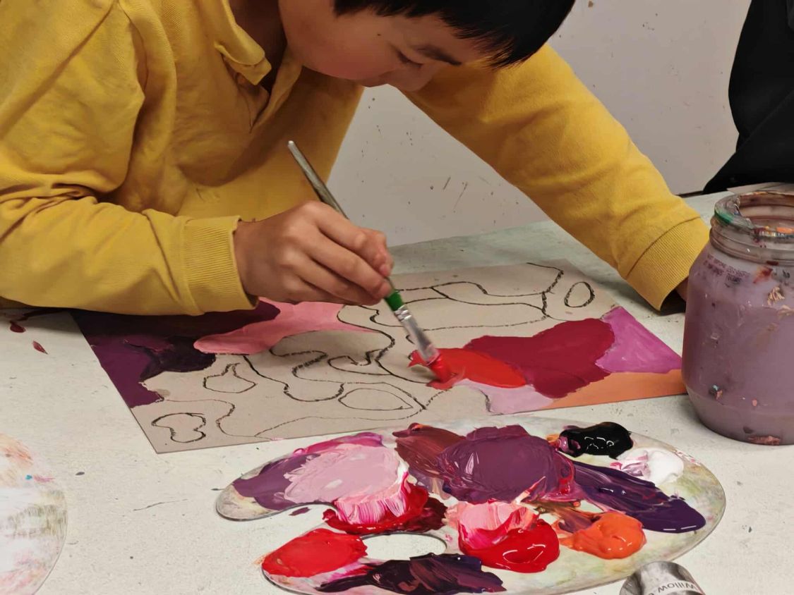 Student focused on mixing paint colours