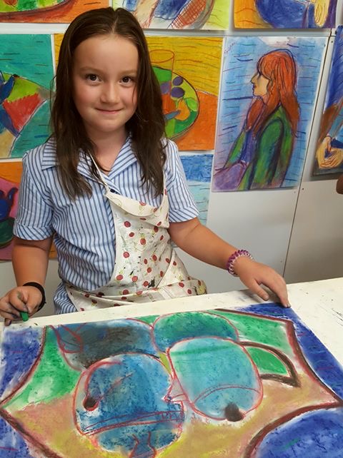 Student showing off her pastel drawing