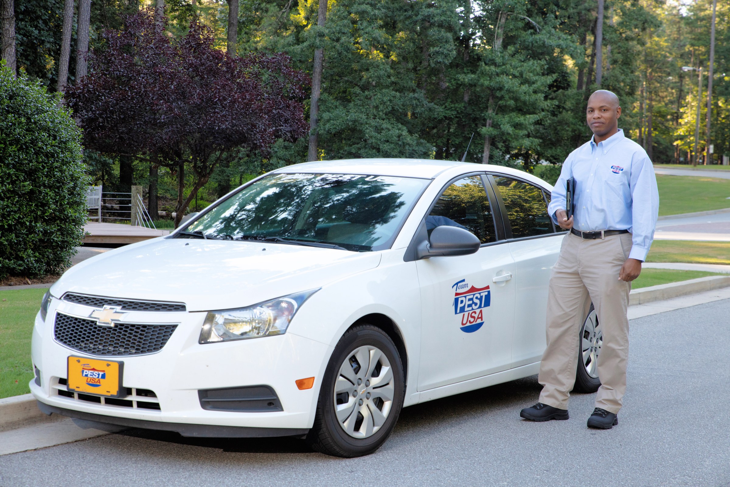 Team Pest USA technician standing beside a branded service vehicle.