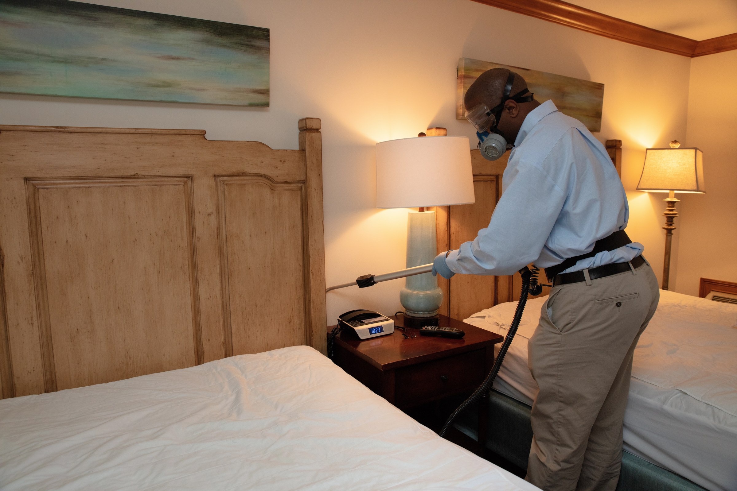 Team Pest USA technician treating a hotel guest room.
