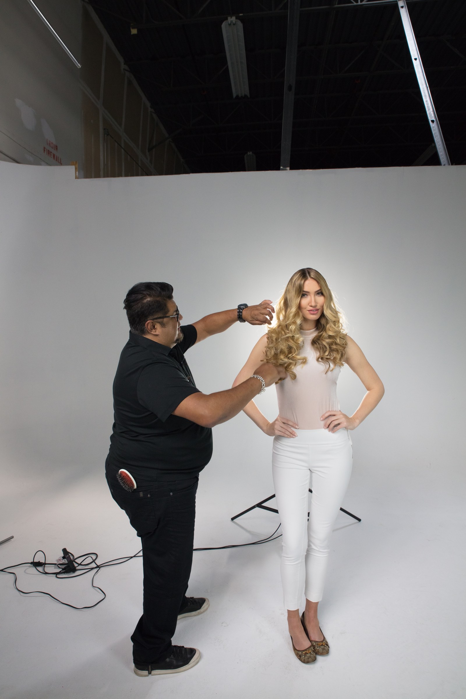 George Alderette styling a model's hair during the studio photo shoot.