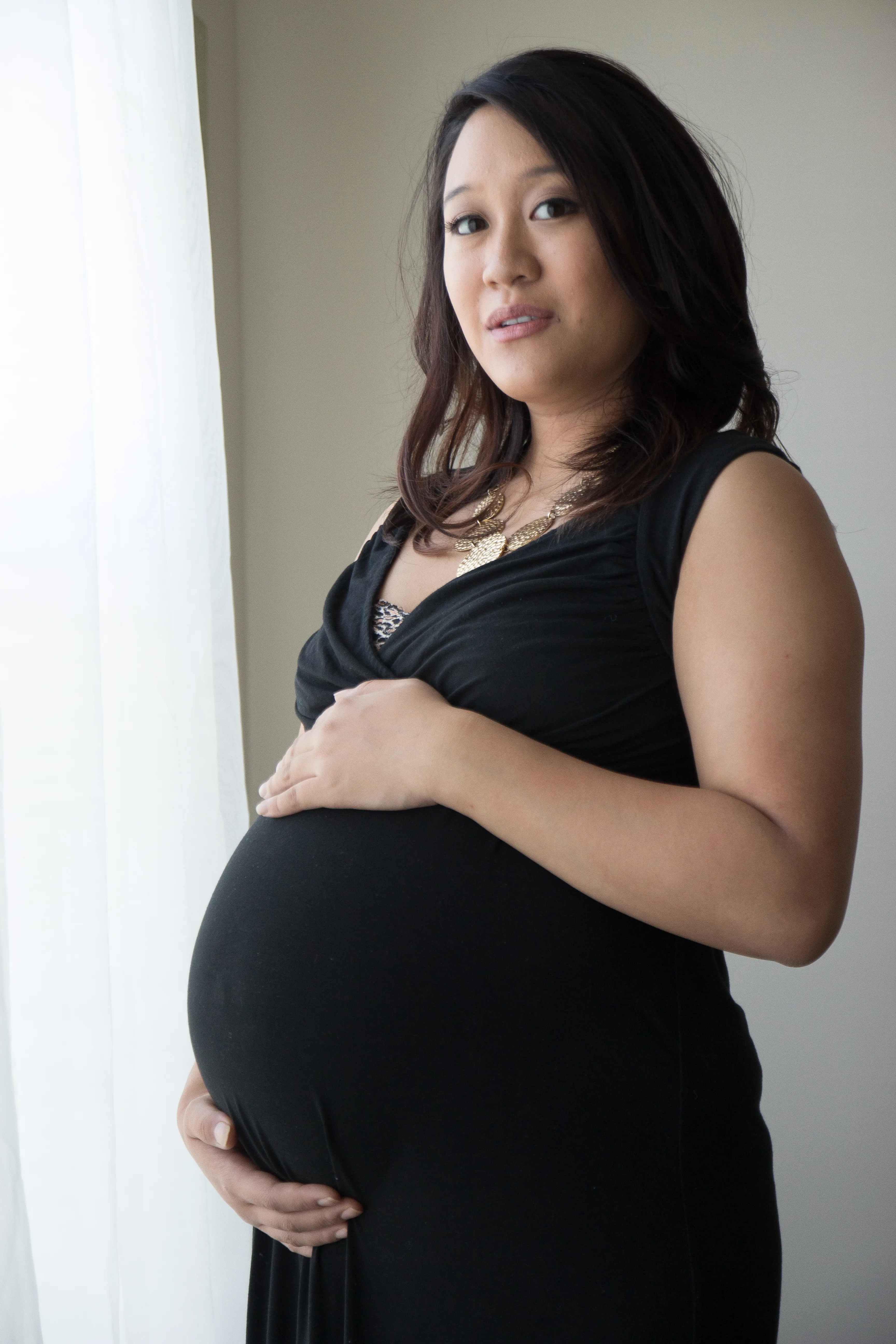 Kristen in a black dress during an at-home maternity portrait session
