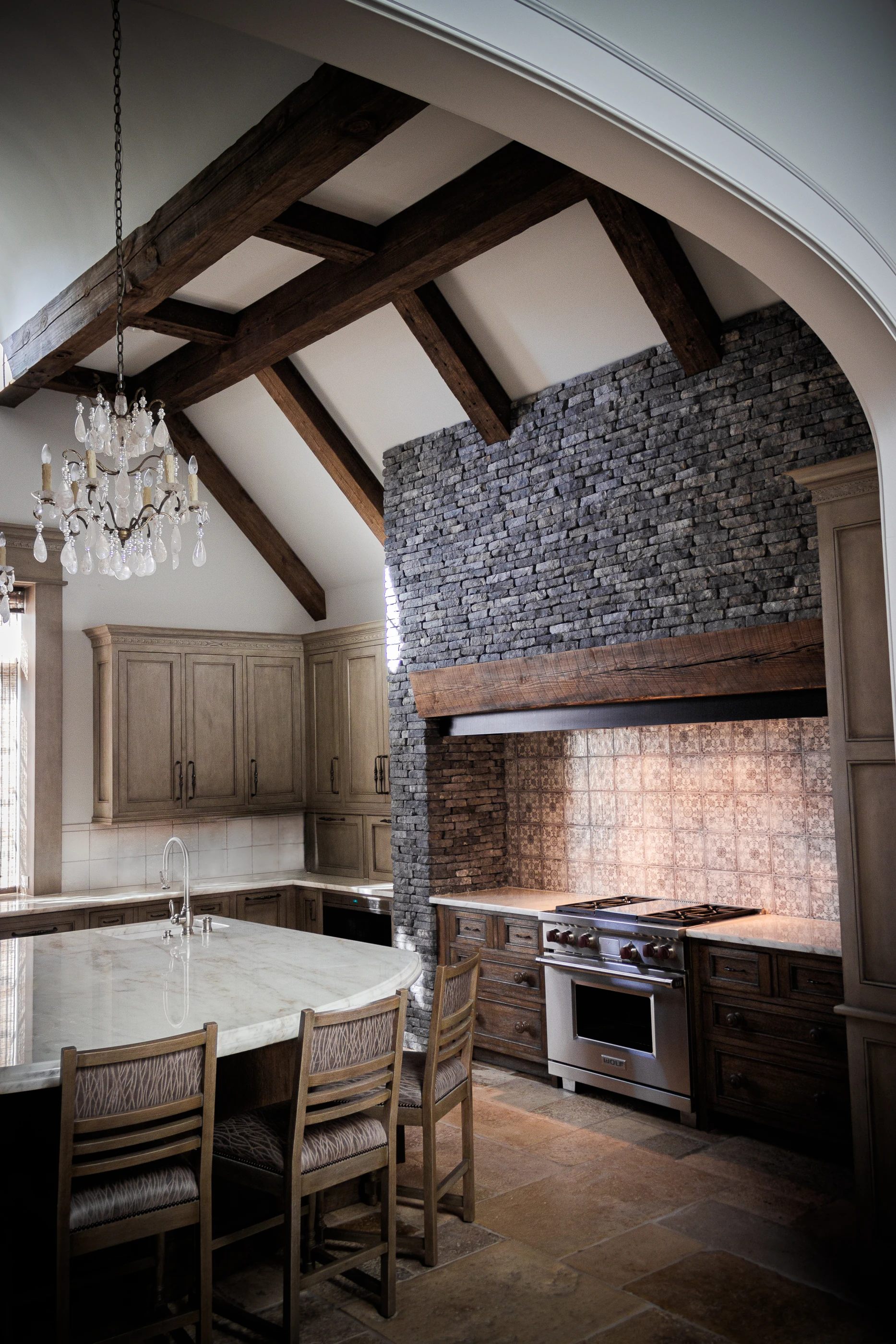 Jessamine County Farm kitchen with timber beams, a stone range hood and a stone-topped island.