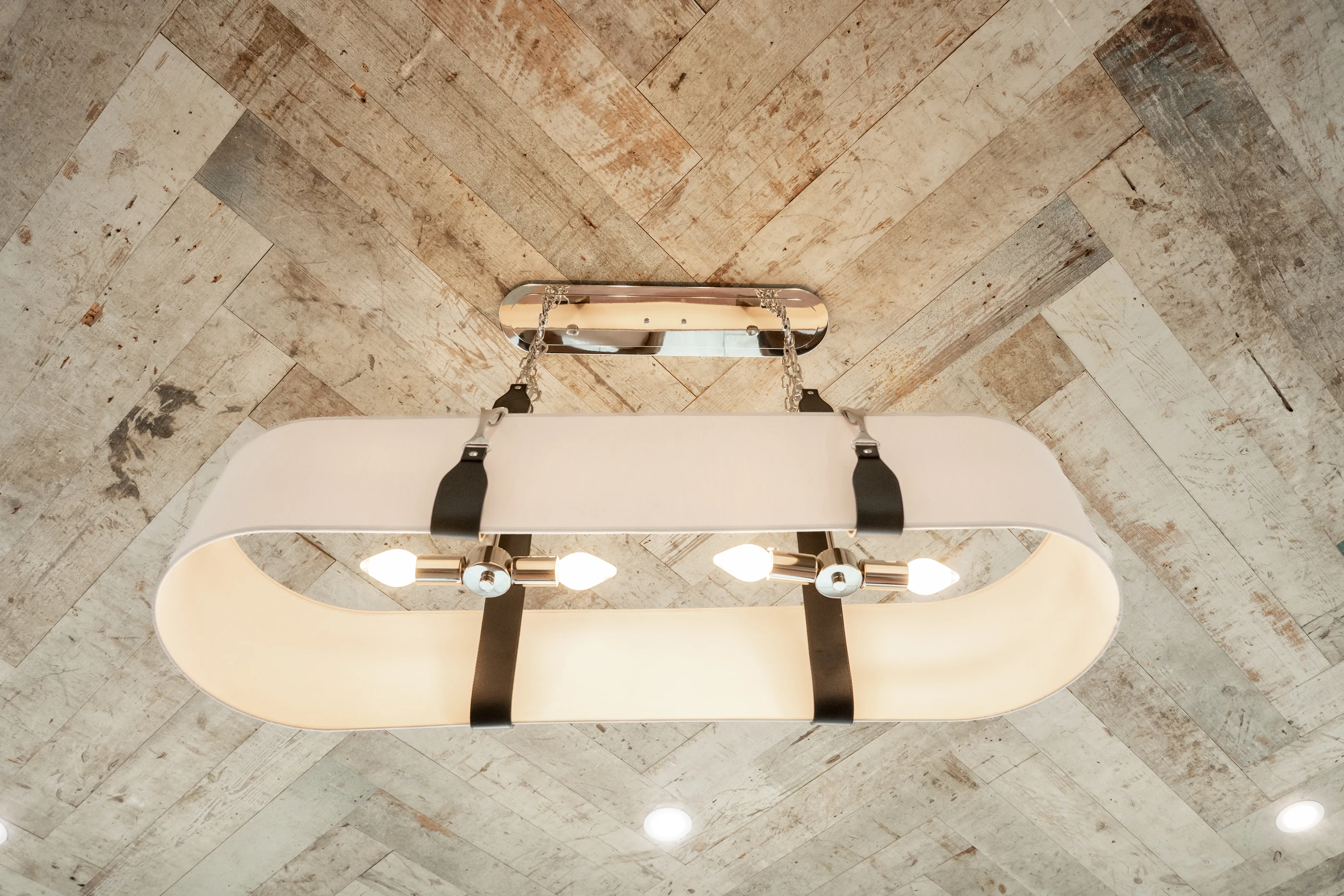 Hart sculptural pendant beneath a patterned timber ceiling.