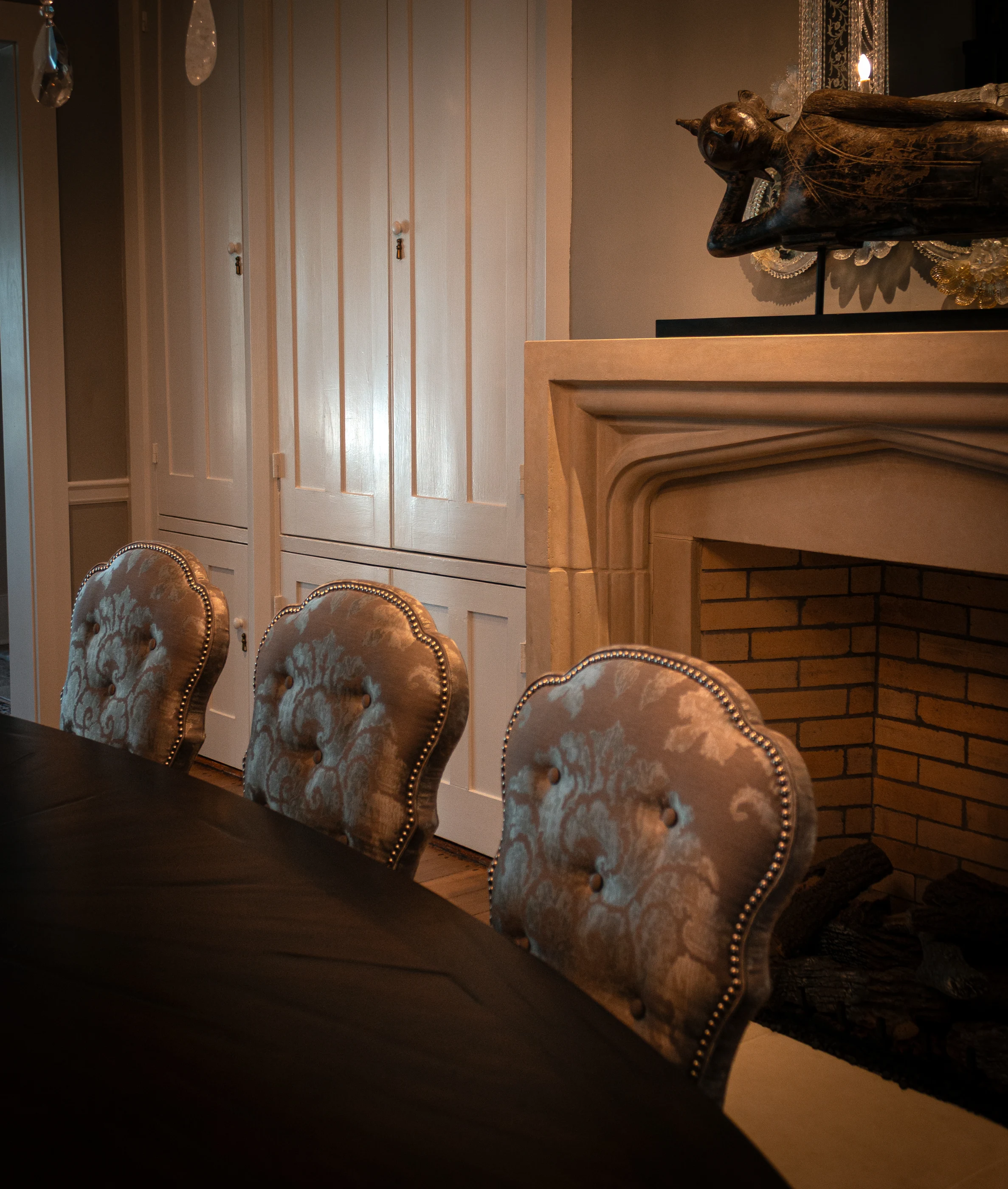 Upholstered dining chairs beside the fireplace at Equestrian Estate.