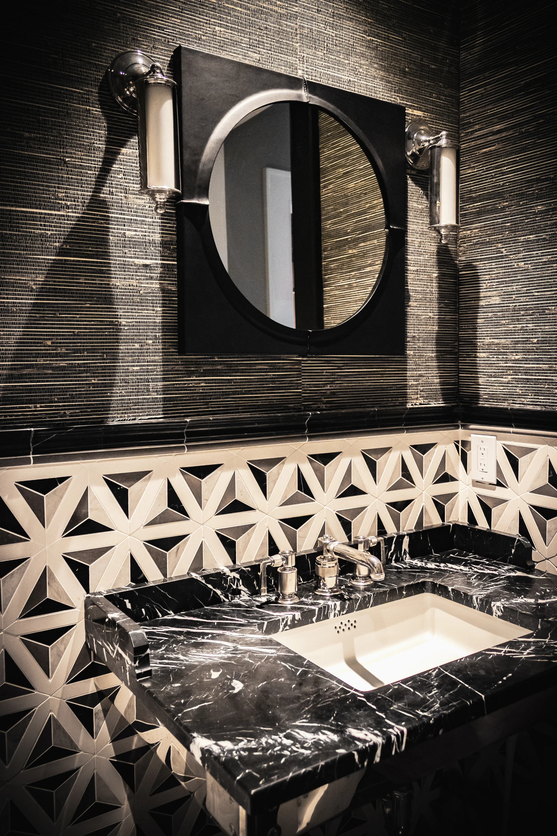 Dark stone vanity with geometric wall tile at Equestrian Estate.
