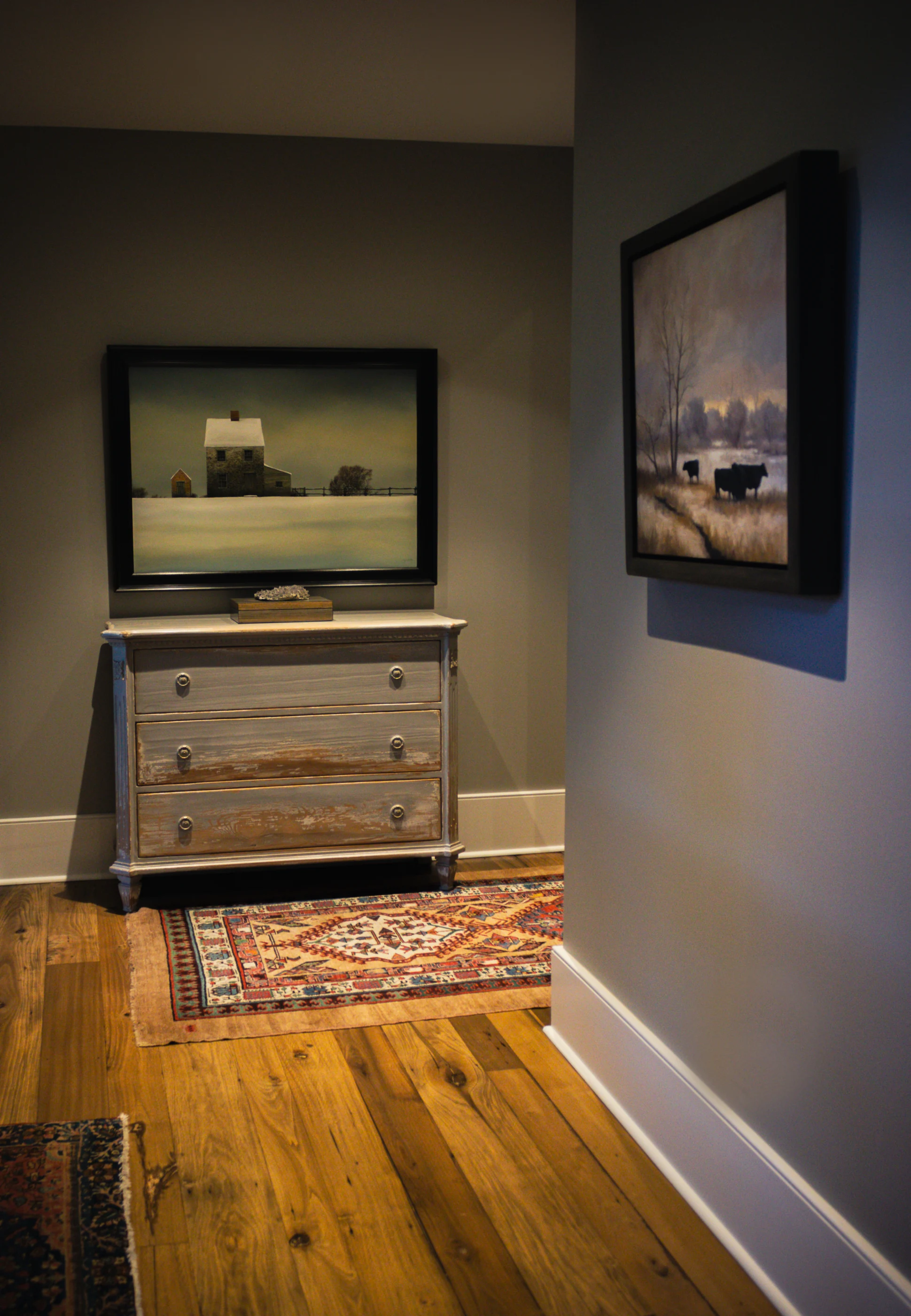 Antique chest and artwork in a quiet passage at Equestrian Estate.