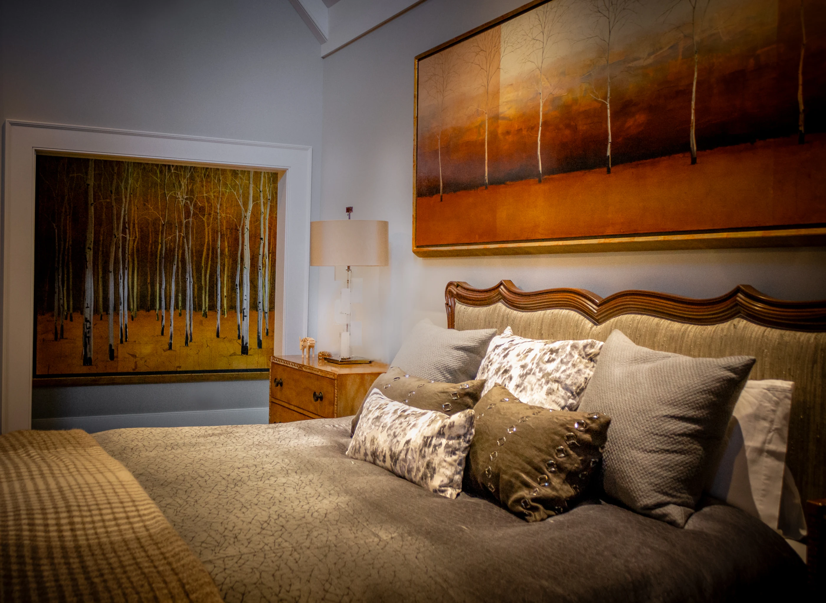 Layered bedding beneath expressive landscape art at Equestrian Estate.