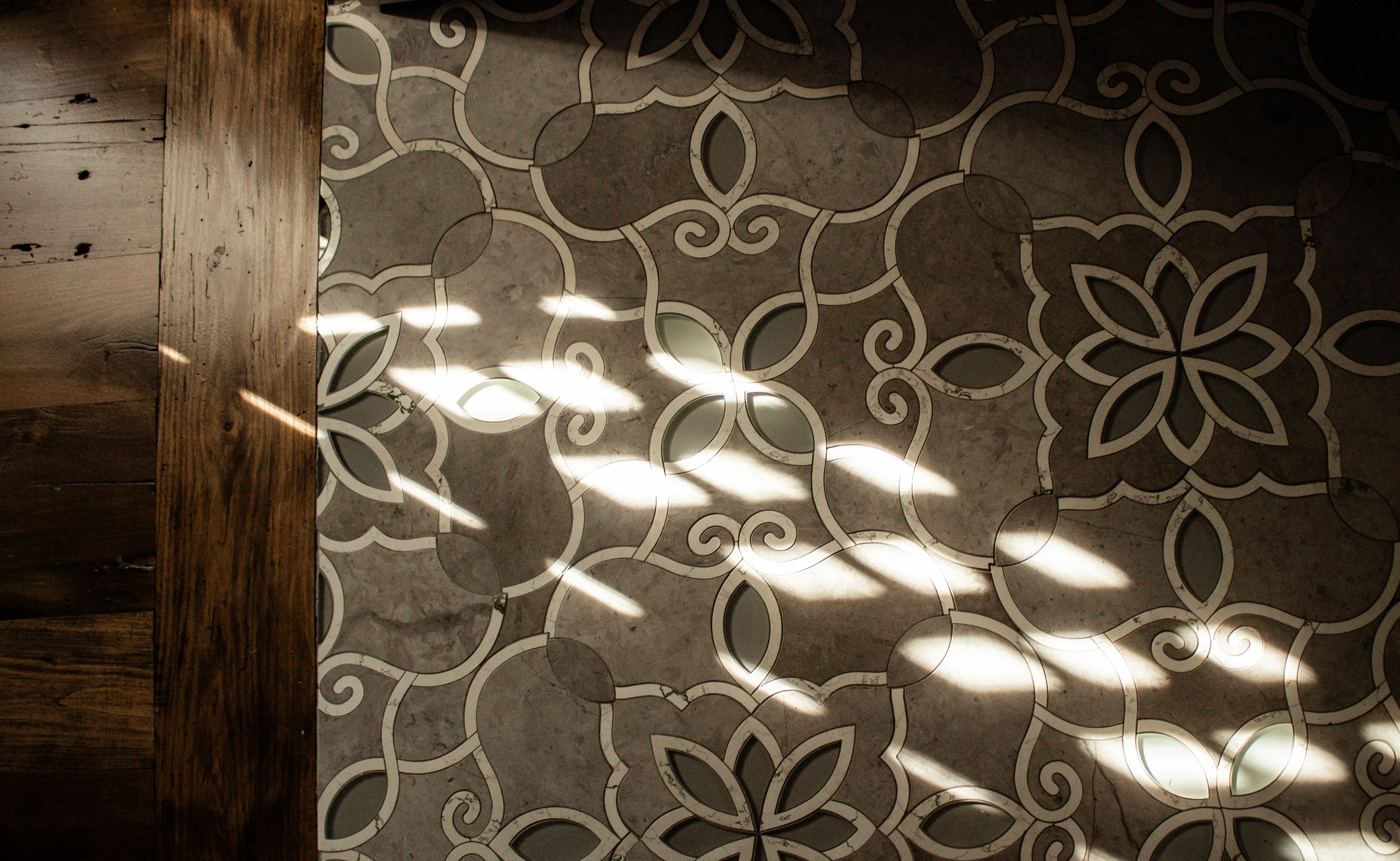 Patterned stone floor in filtered sunlight at Equestrian Estate.
