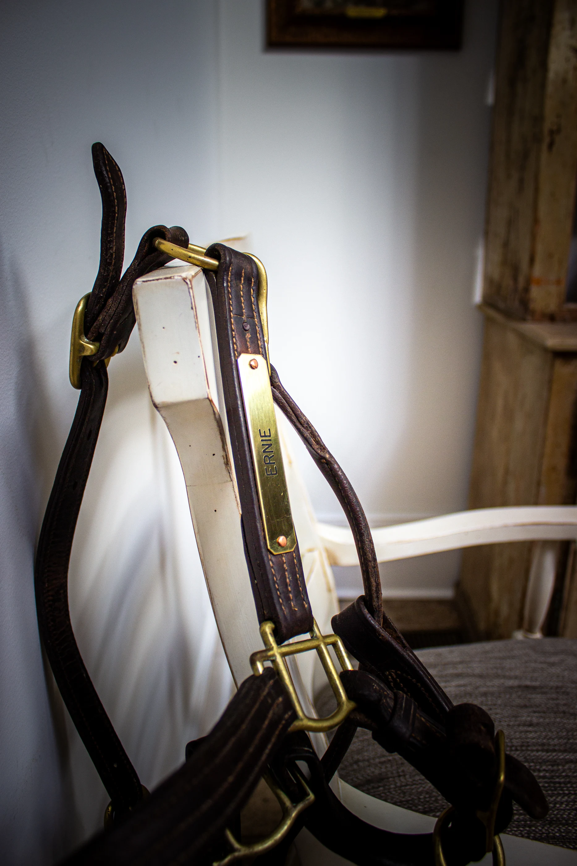 Equestrian tack displayed on a pale timber chair at Equestrian Estate.