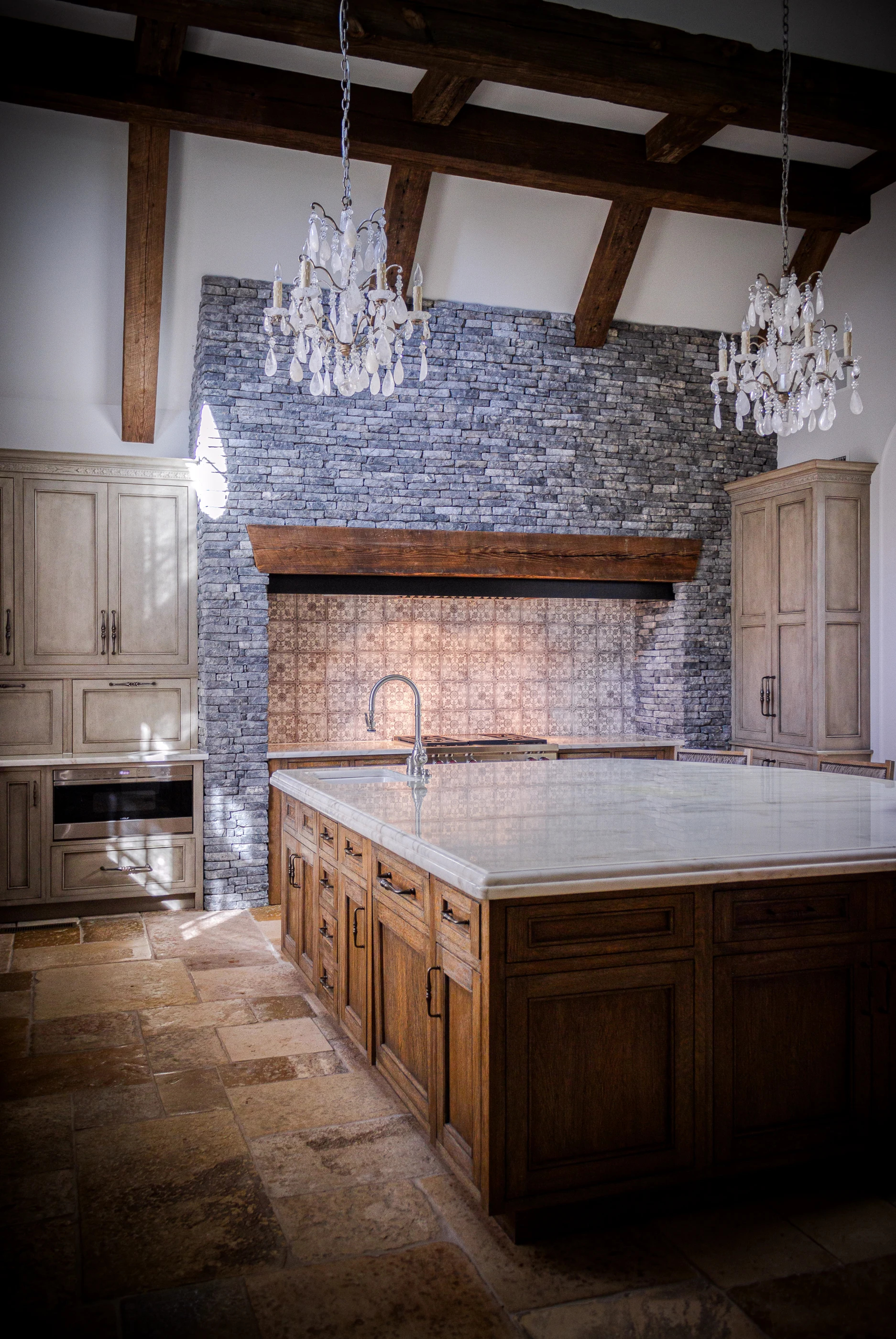 Kitchen with timber island and stone range hood at Equestrian Estate.