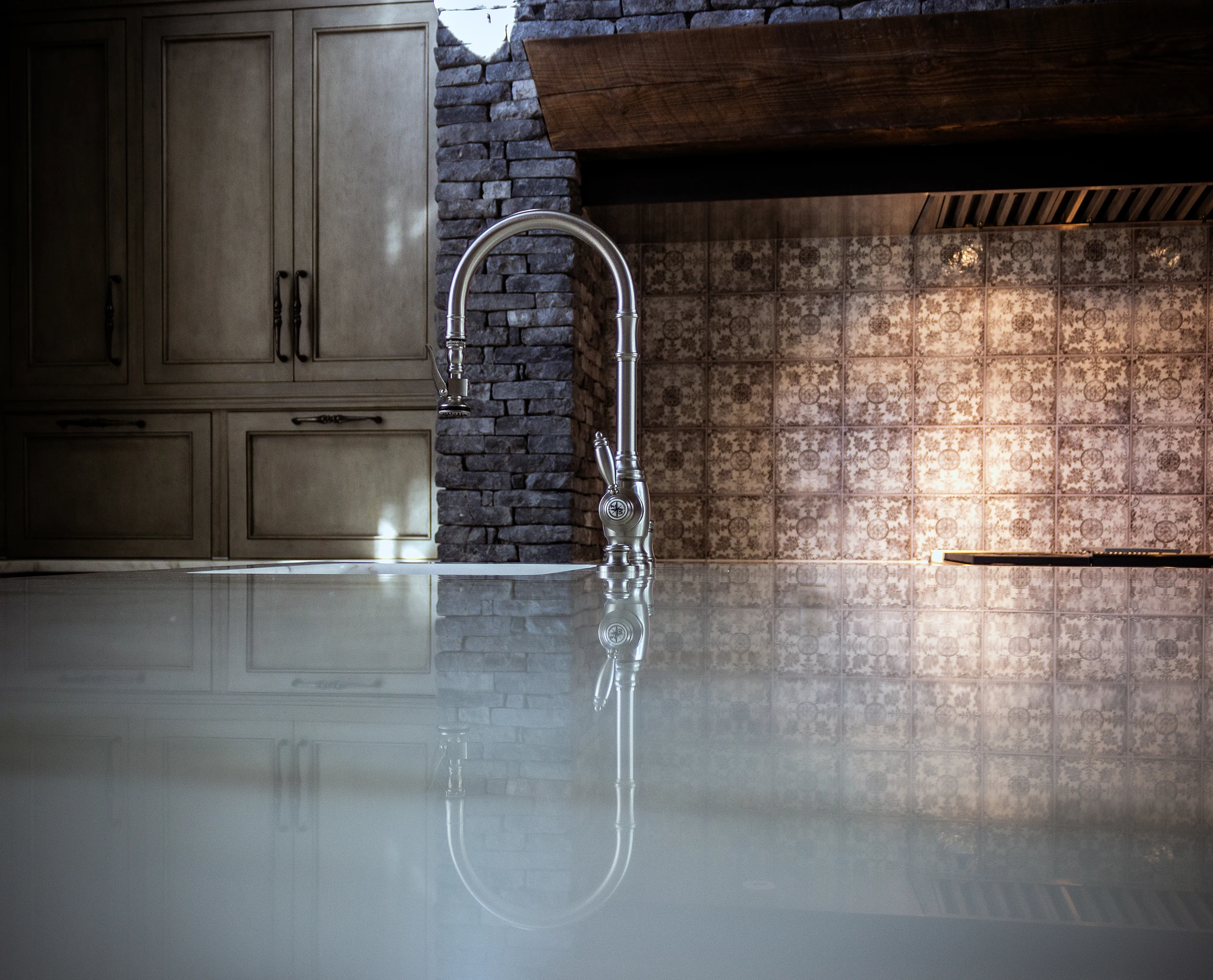 Kitchen faucet reflected in the stone island at Equestrian Estate.