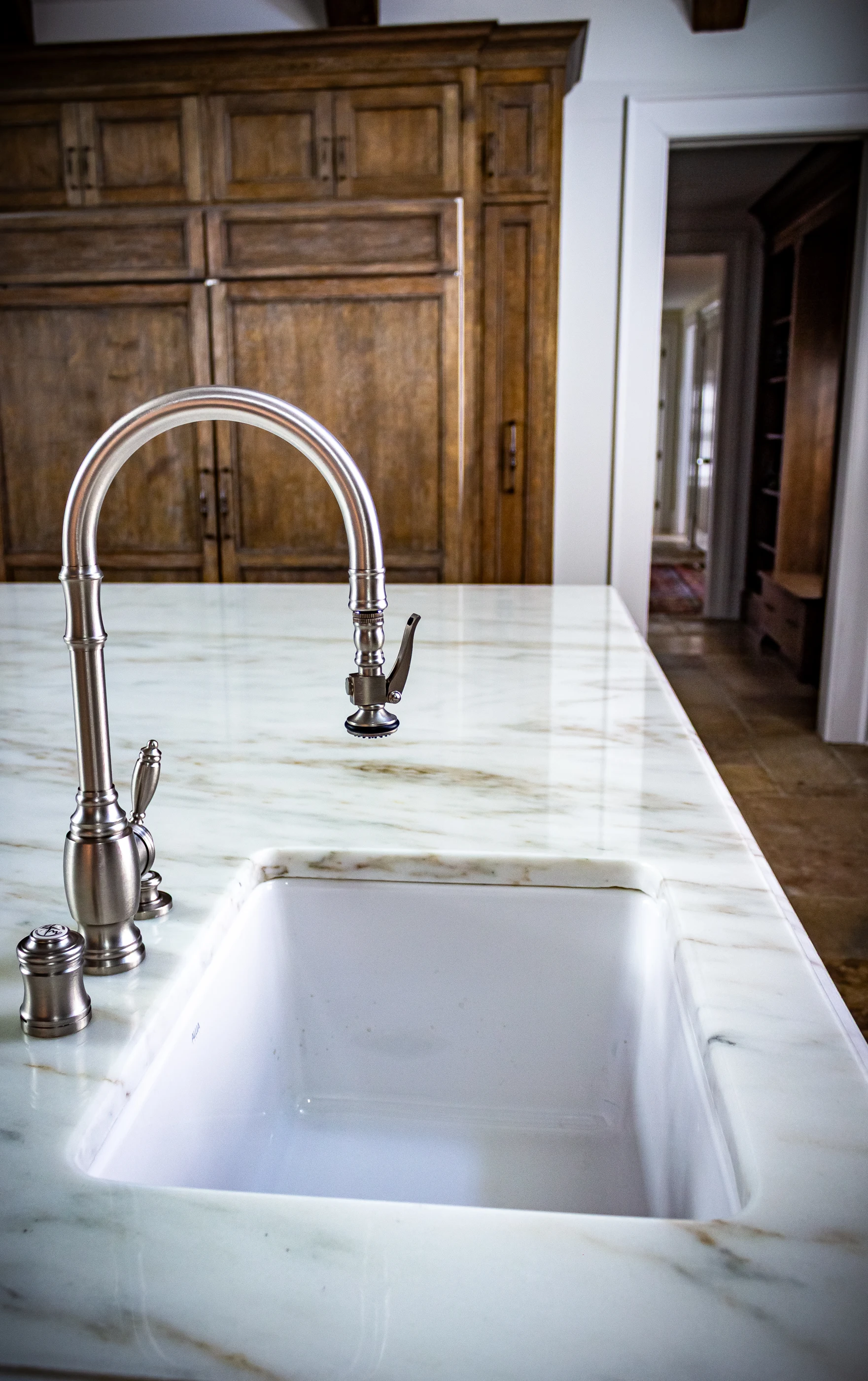 Deep kitchen sink in a pale stone countertop at Equestrian Estate.