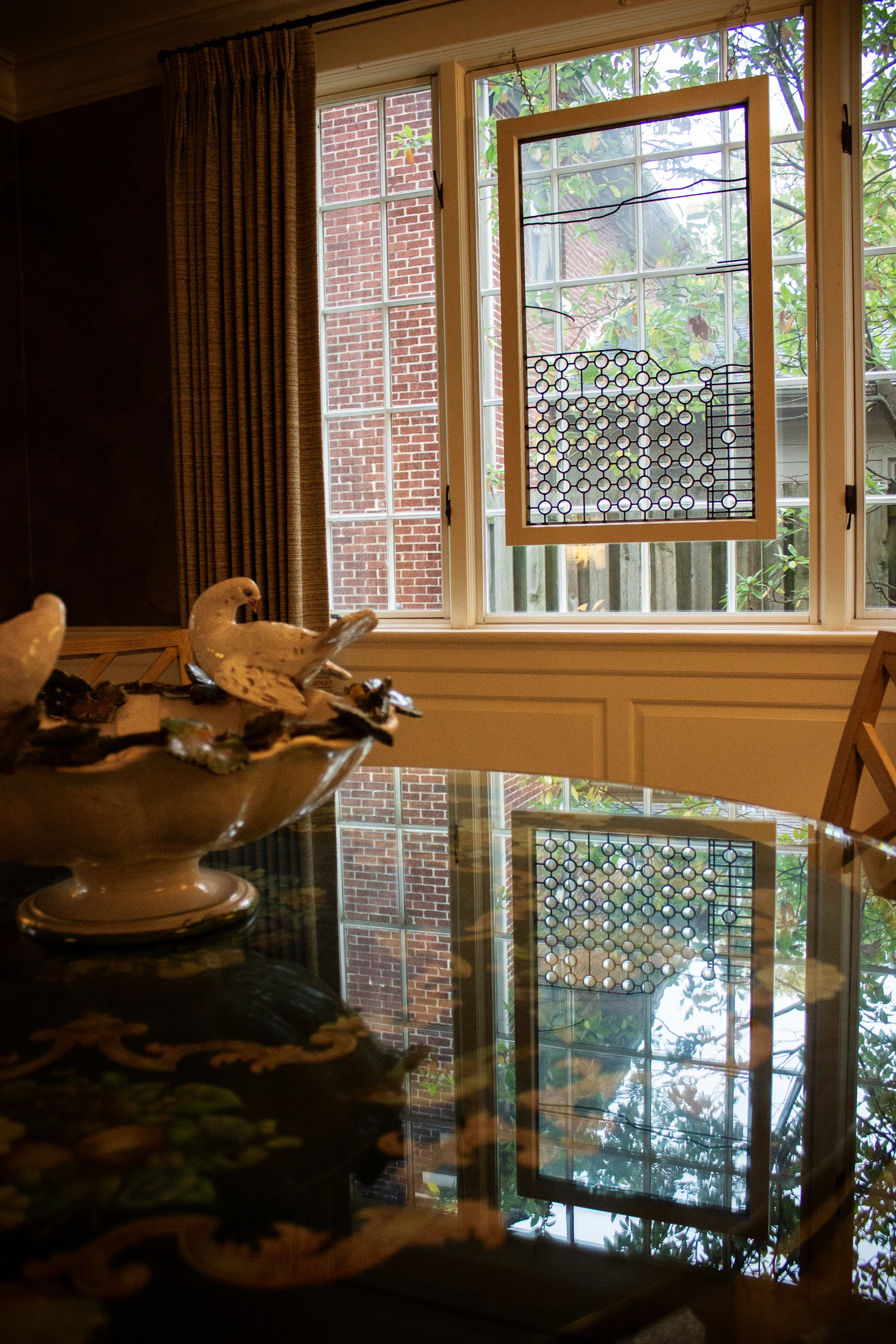 Dining table reflecting the patterned window at Ashland Park.