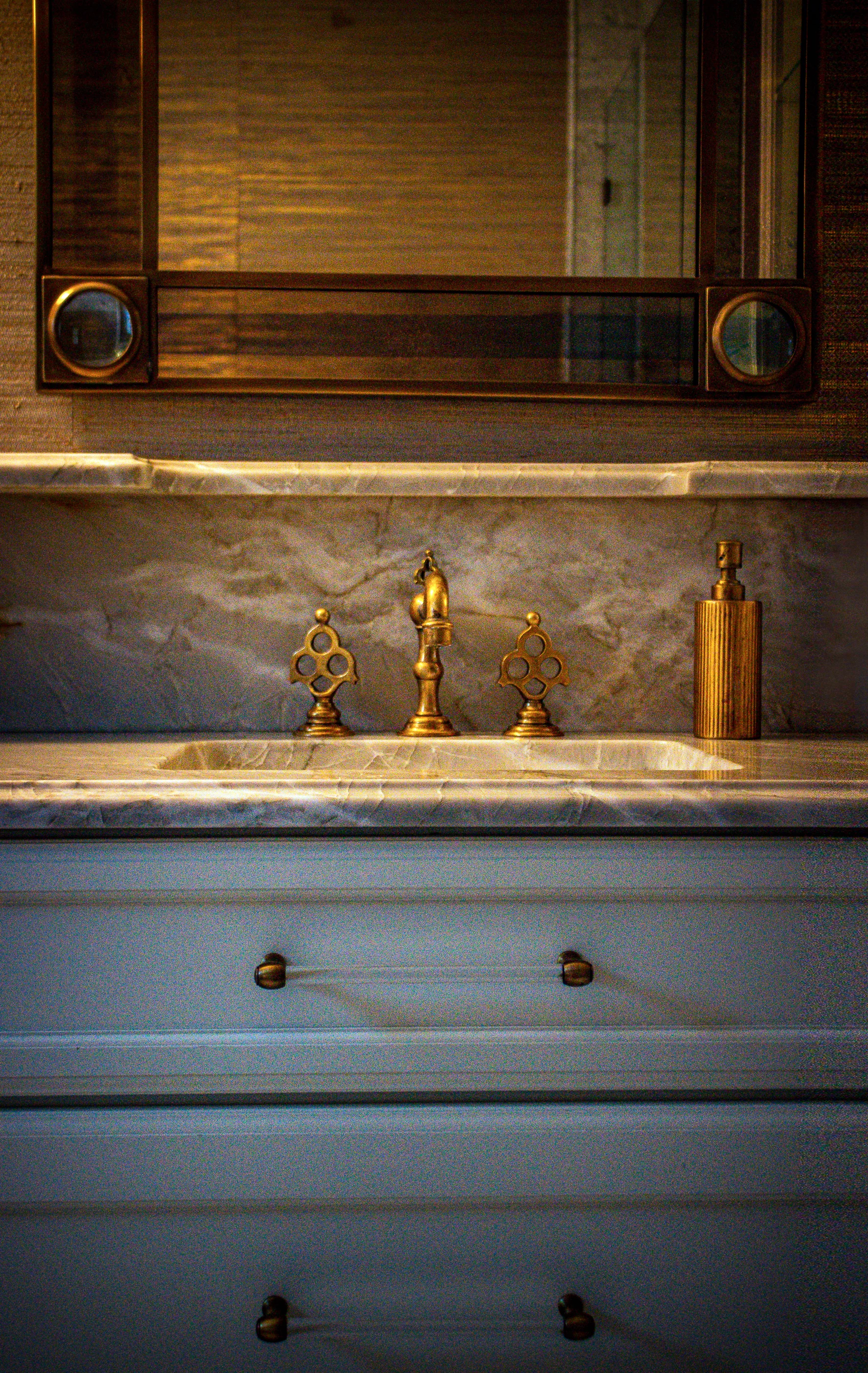 Pale vanity with marble backsplash and brass fittings at Ashland Park.