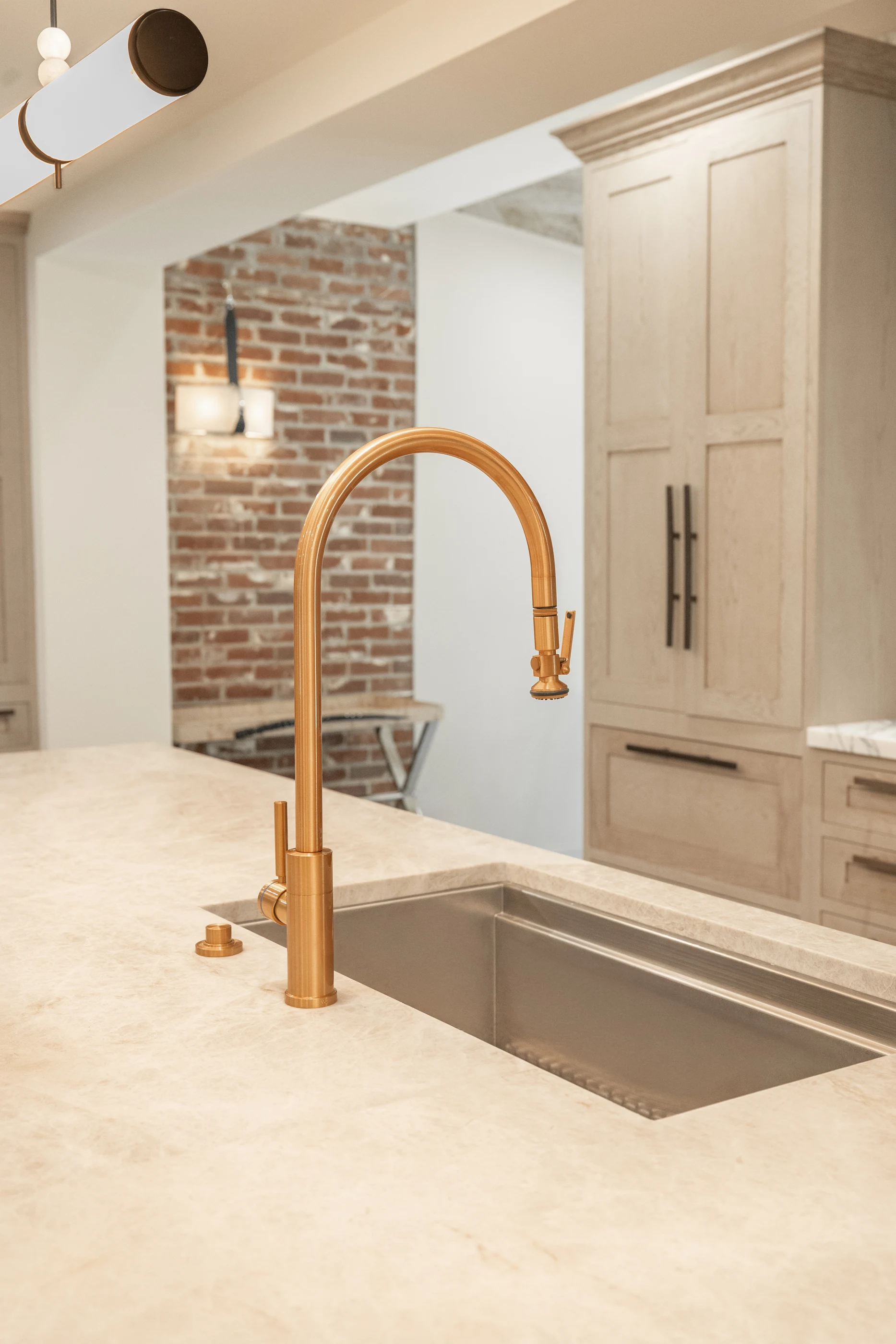 Copper faucet above the pale stone kitchen island at Hart Townhouse.