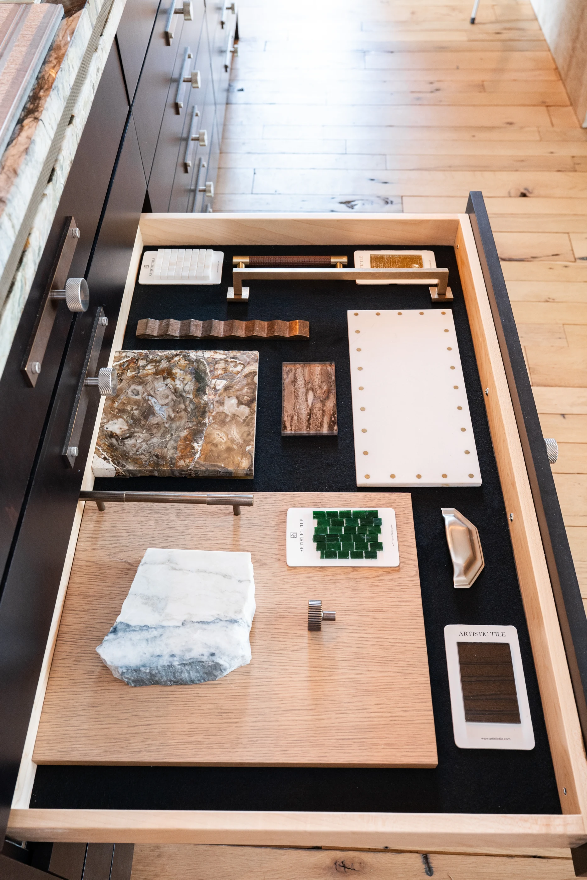 Material samples arranged in a fitted drawer in the Cabinet & Stone Lab showroom.