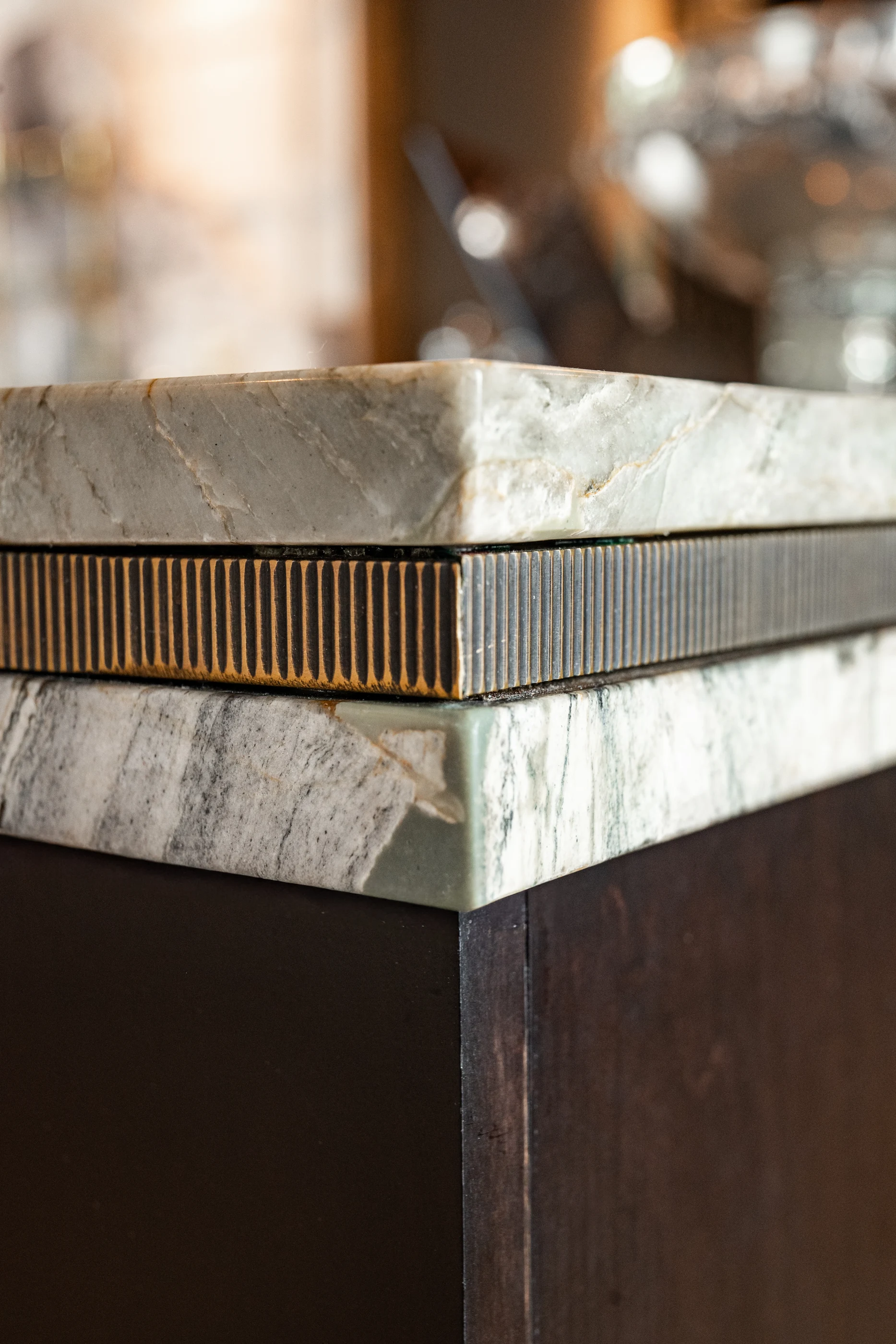 Layered countertop edge with fine metal detailing in the Cabinet & Stone Lab showroom.