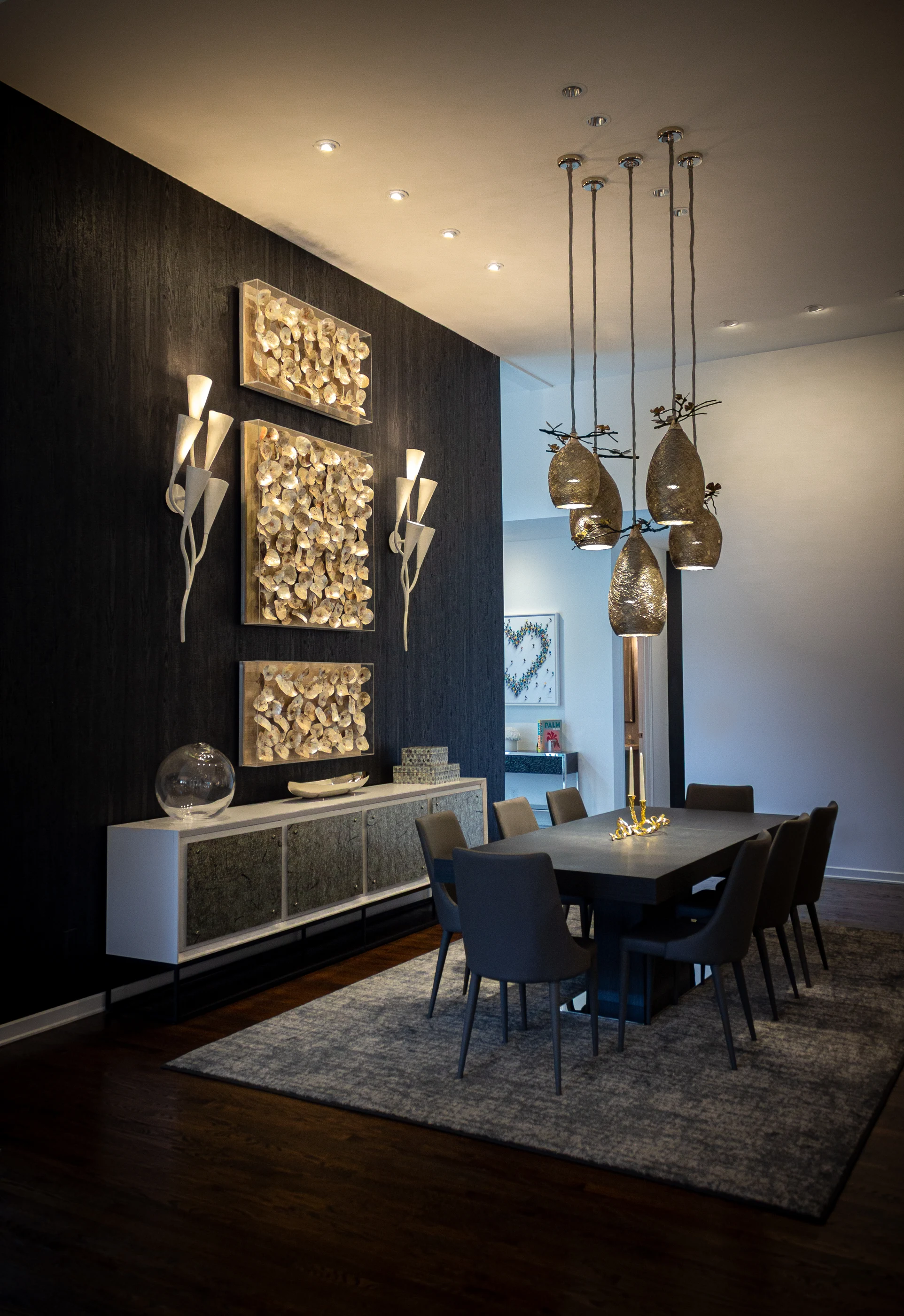 Dining room with textured wall art and sculptural pendant lighting at Urban Mod.