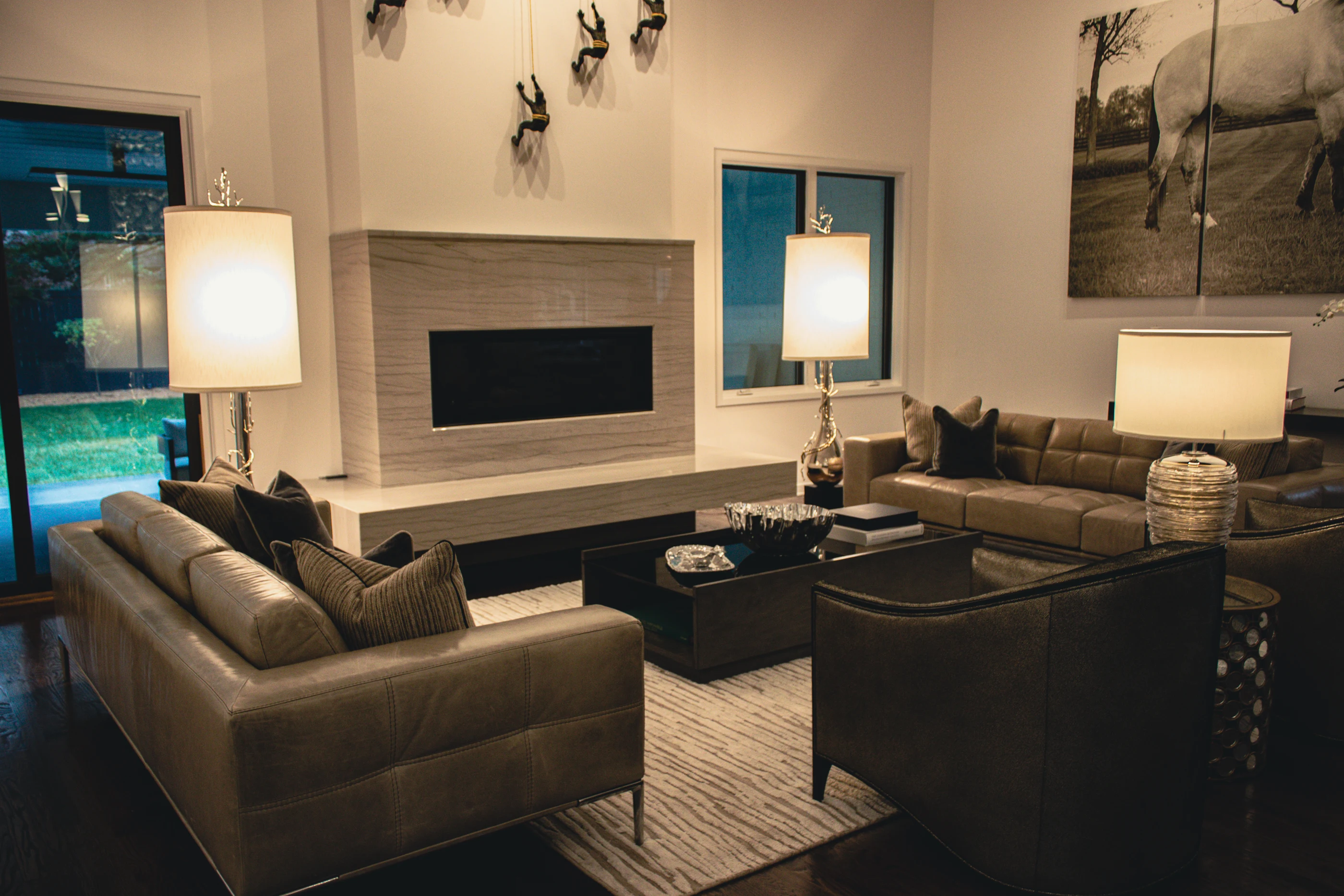 Living room with a linear fireplace, layered seating and sculptural lamps at Urban Mod.
