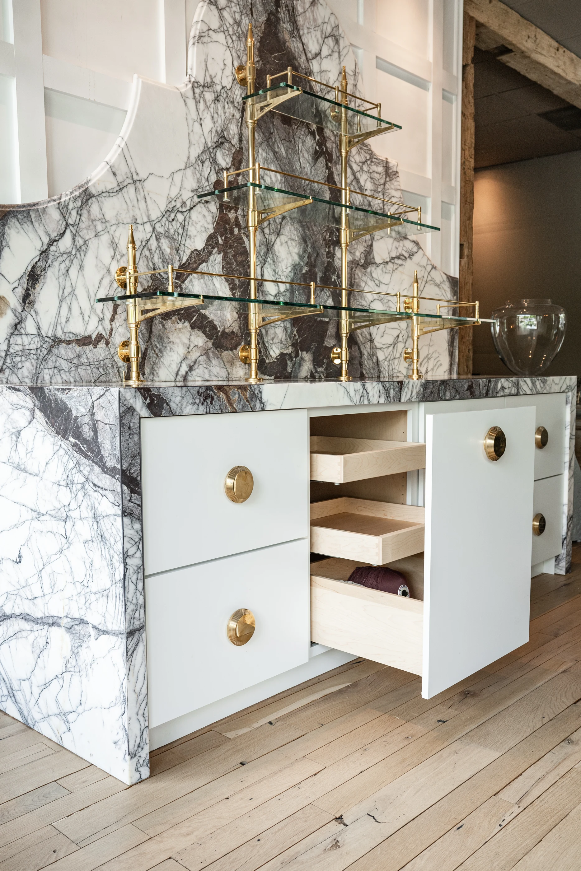 Cabinet storage beneath a veined stone display in the Cabinet & Stone Lab showroom.