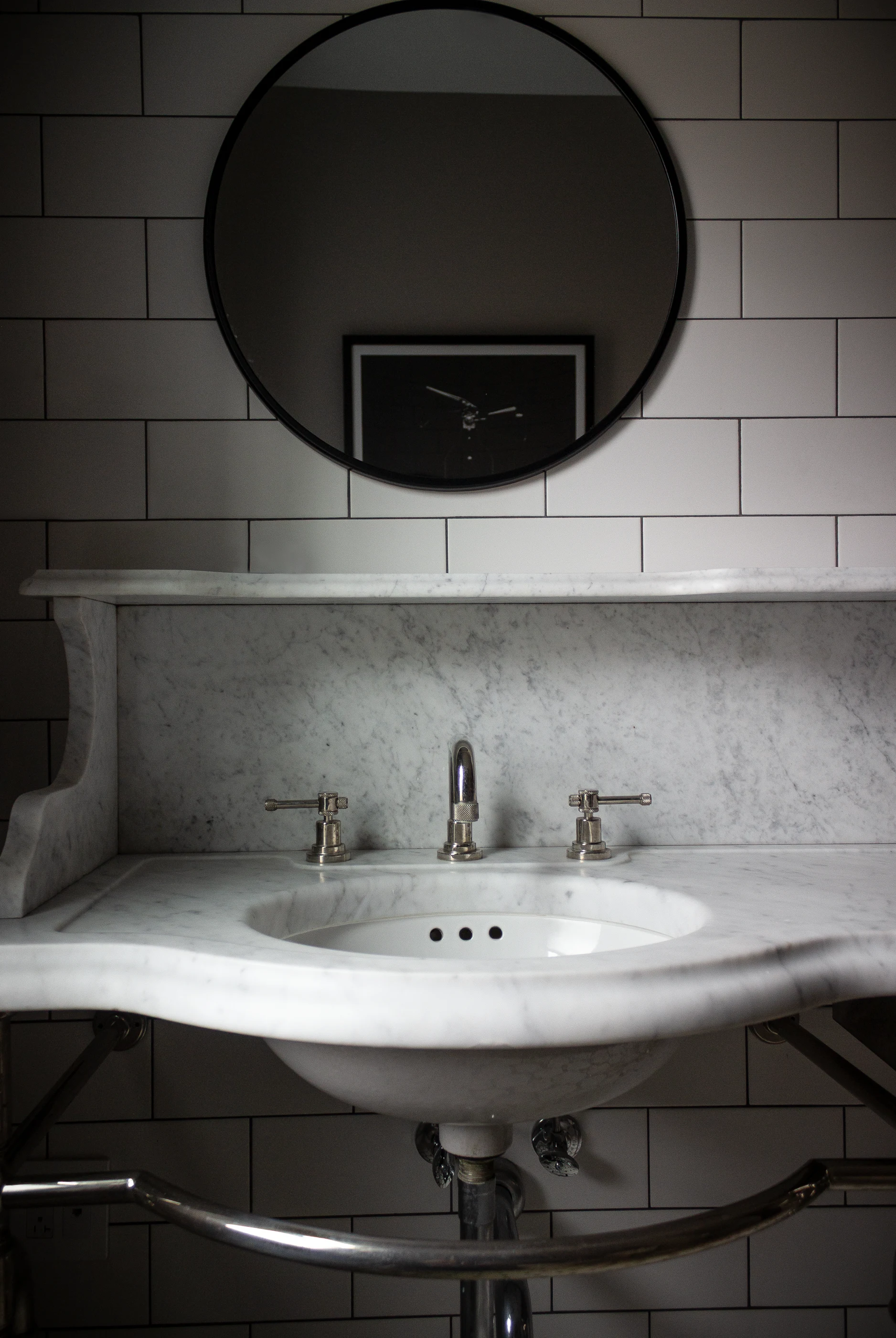 Stone basin beneath an oval mirror at Chevy Chase.