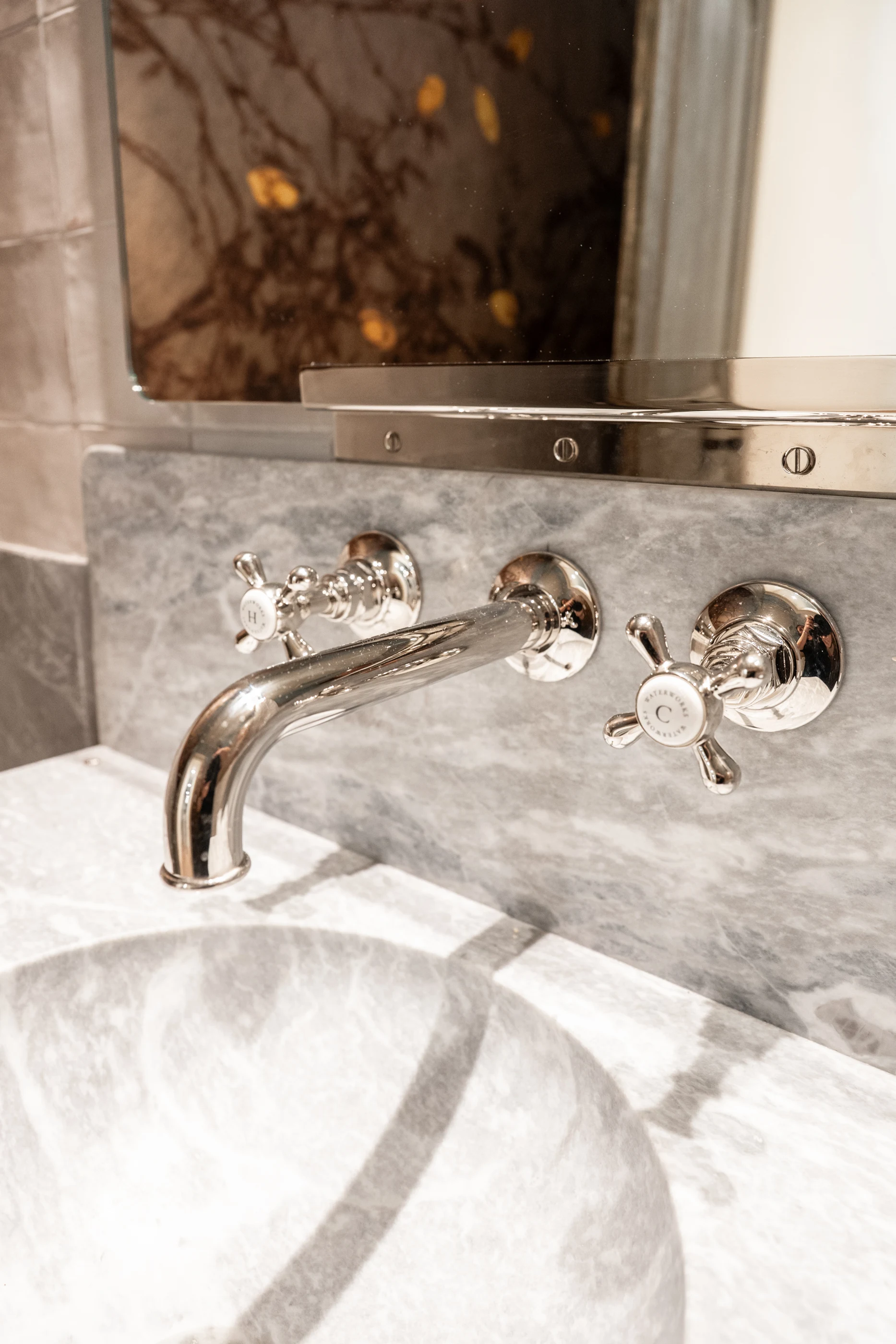 Polished faucet and veined stone vanity detail at Hart Townhouse.